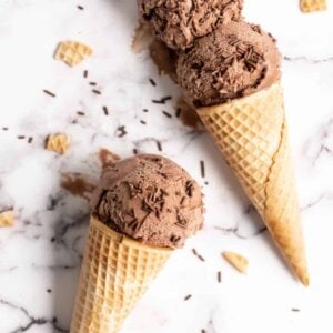 Chocolate Avocado Ice Cream in two cones on marble slab