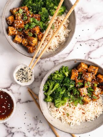 Two bowls of General Tso Tofu with white rice and broccoli