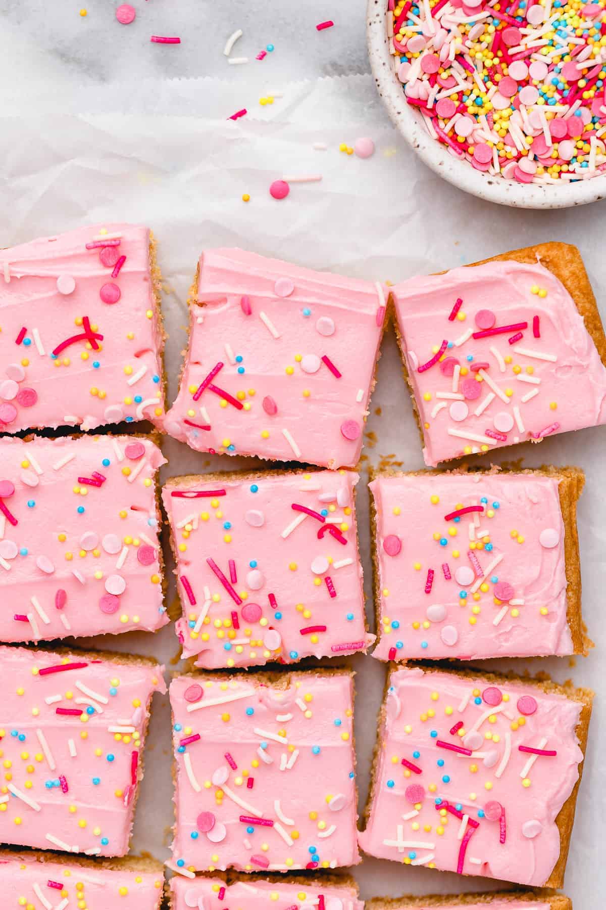 Overhead view of vegan sugar cookie bars with bowl of sprinkles