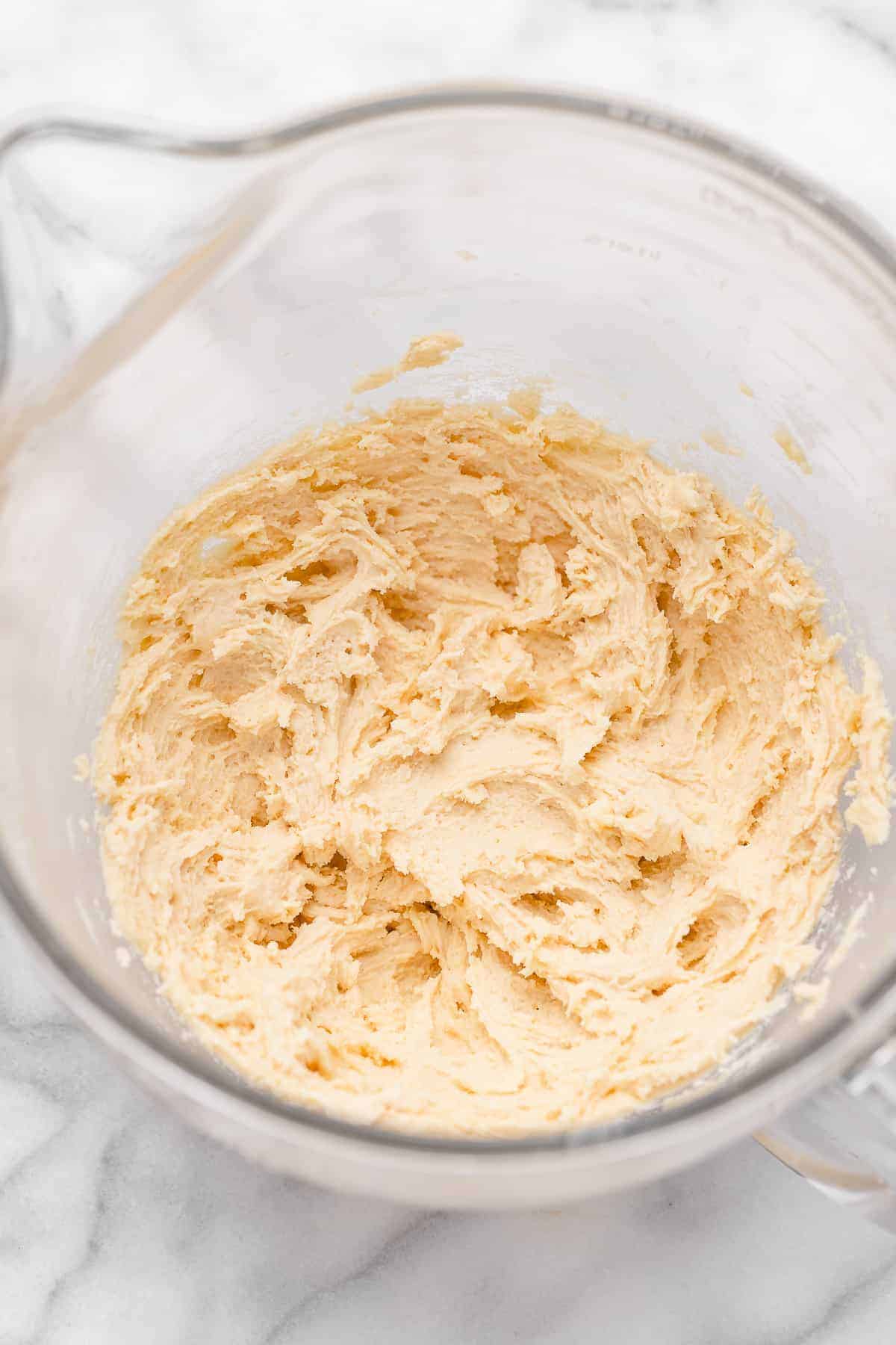 Overhead view of sugar cookie dough in glass mixing bowl