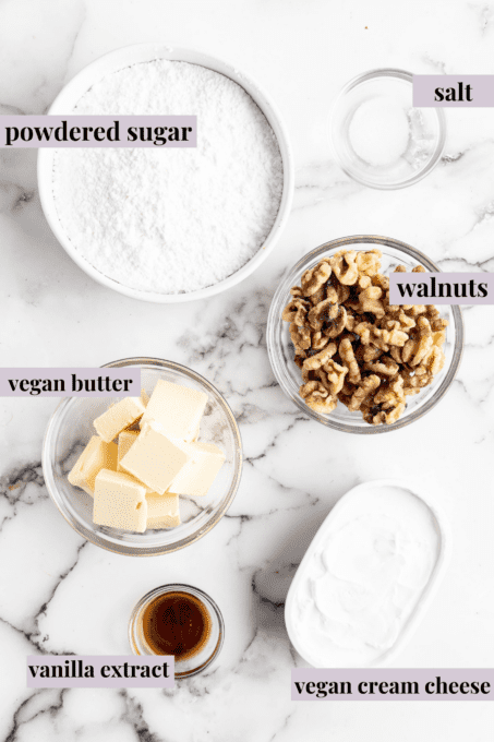 This classic two-layer carrot cake is perfectly spiced, made without dairy or eggs, and frosted with fluffy vegan cream cheese frosting! Overhead view of vegan cream cheese frosting ingredients with labels