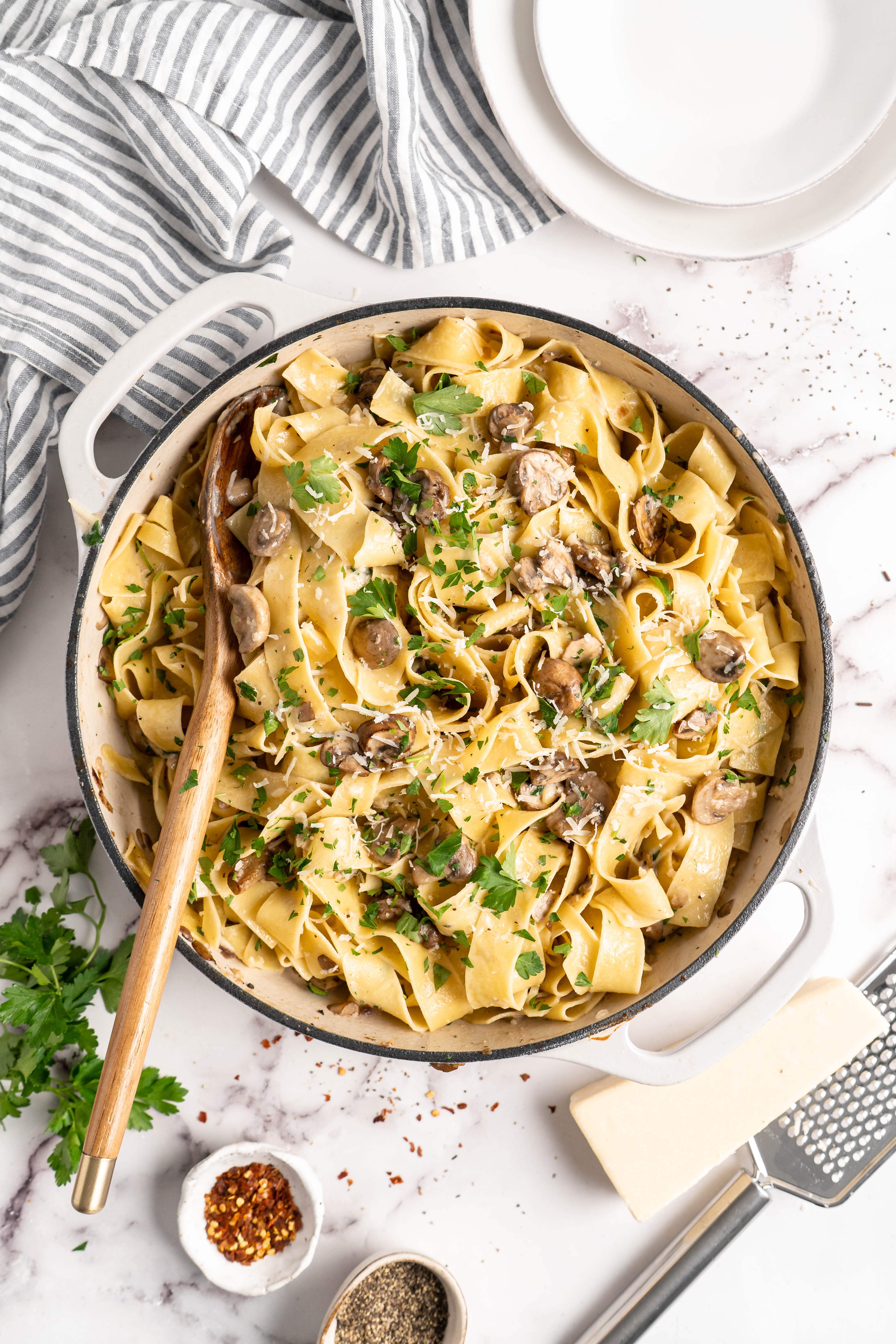 Overhead view of Garlic Mushroom Pasta in pan with wooden spoon