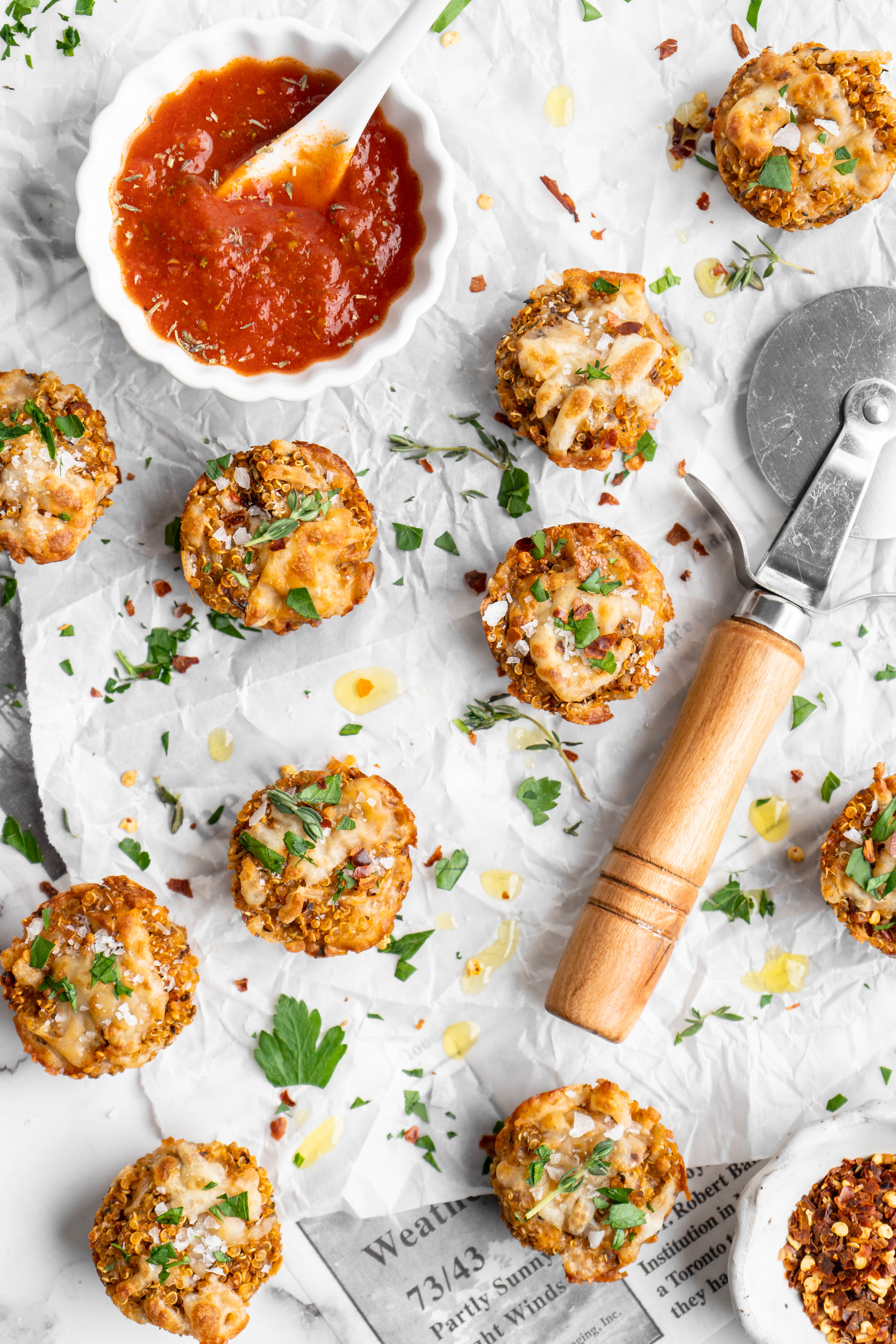 Quinoa pizza bites on parchment paper with small bowl of marinara