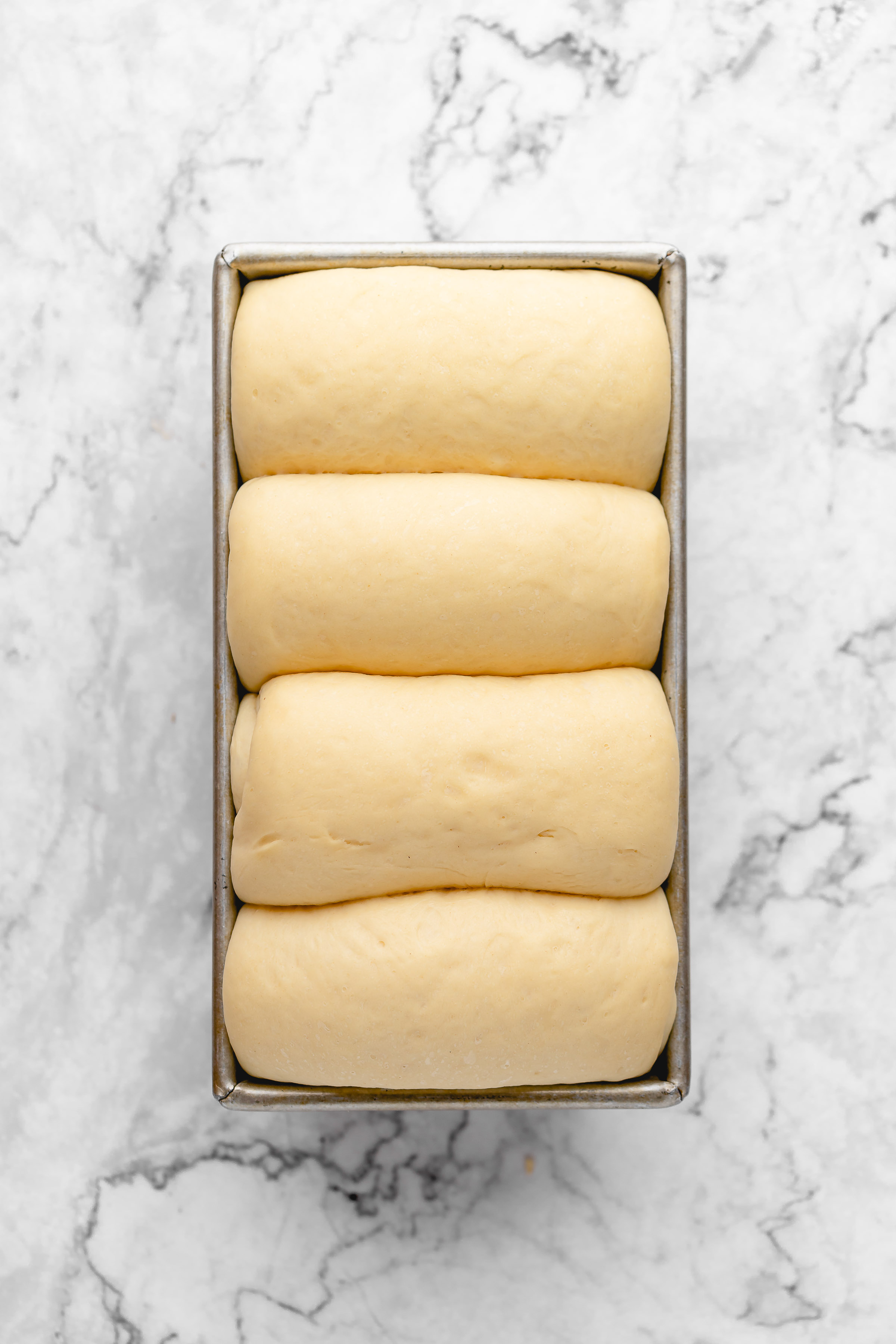 Overhead view of milk bread dough in loaf pan