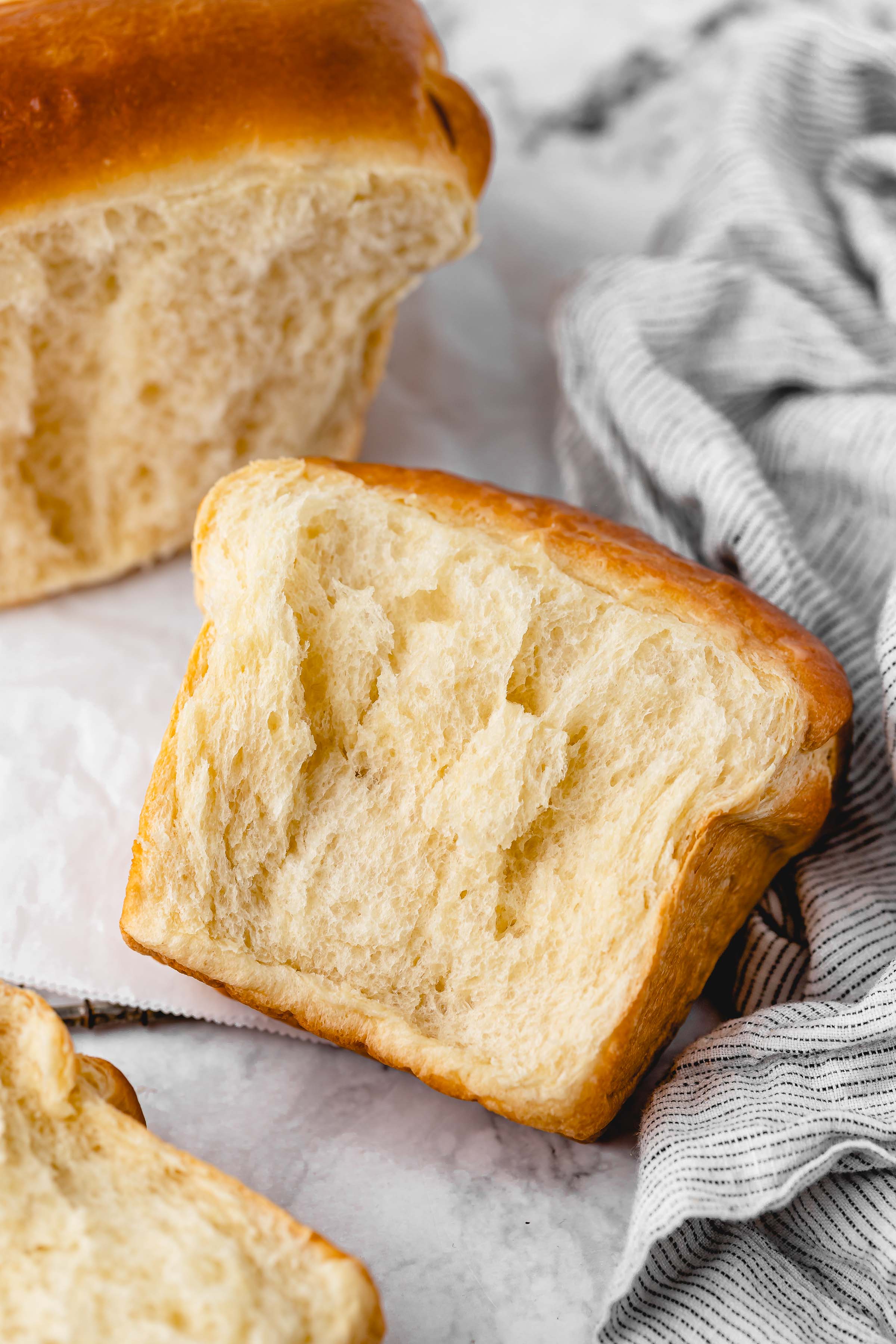Piece of vegan milk bread, showing soft, tender texture