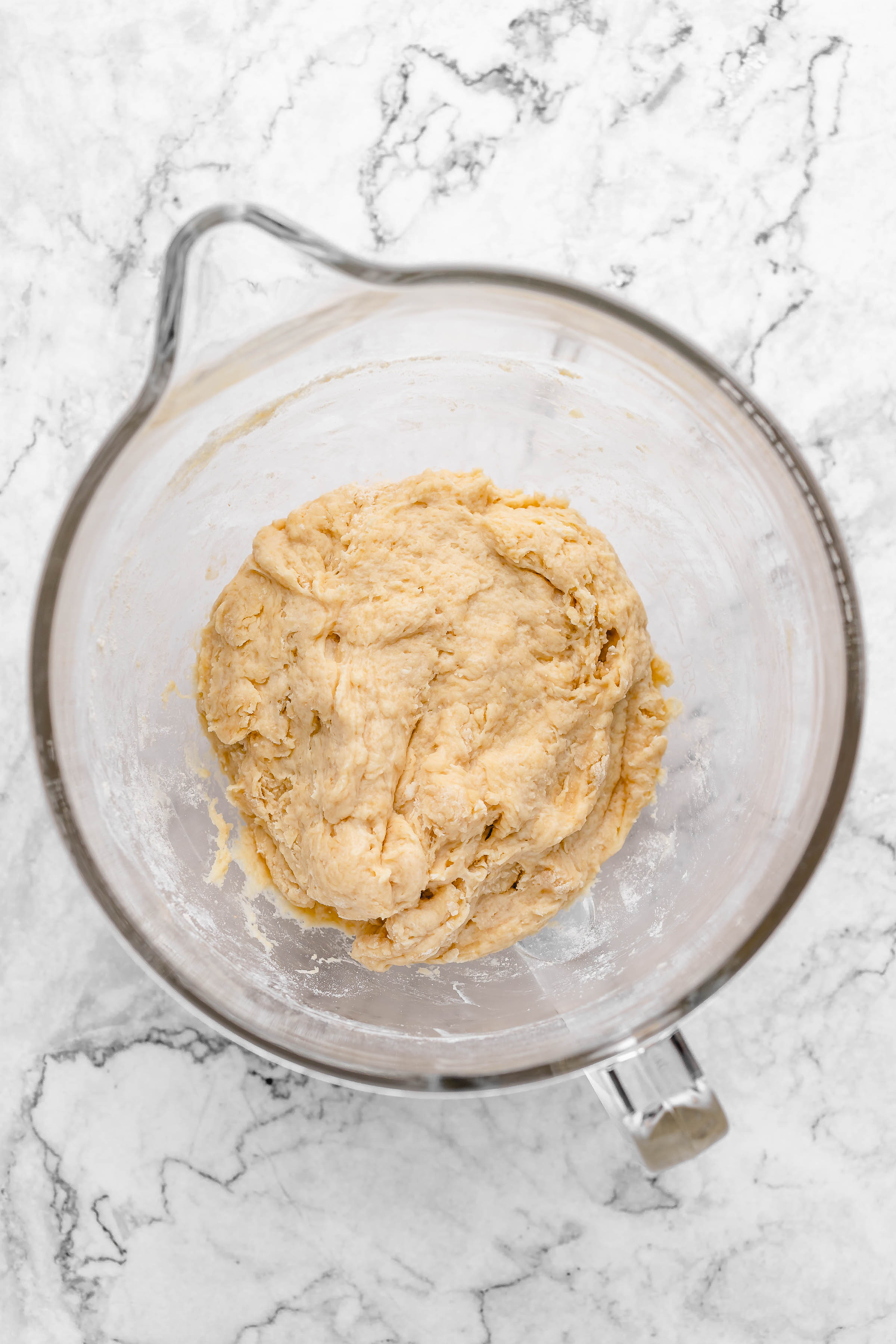 Overhead view of shaggy dough in glass mixing bowl