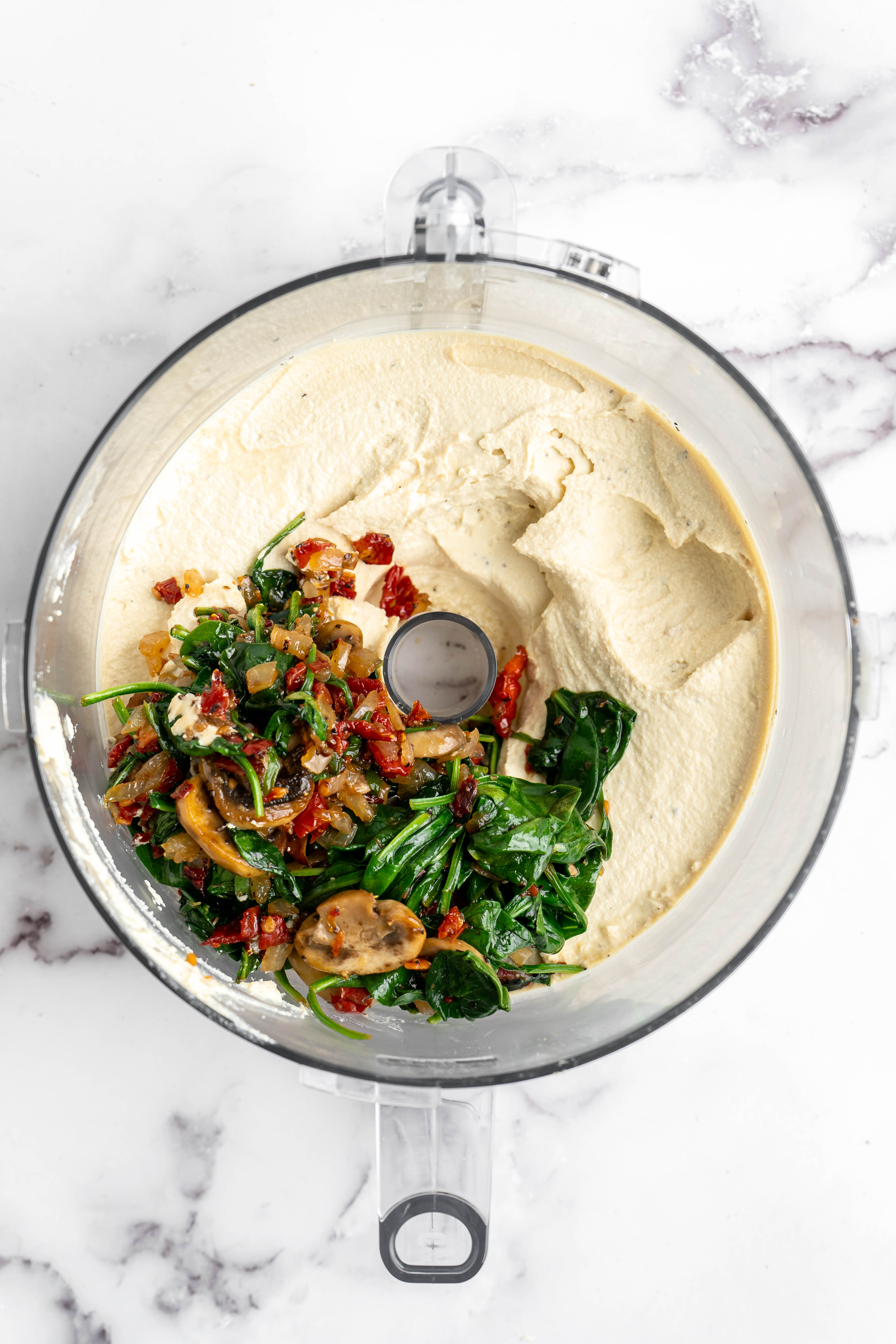 Vegetables added to vegan quiche filling in food processor bowl