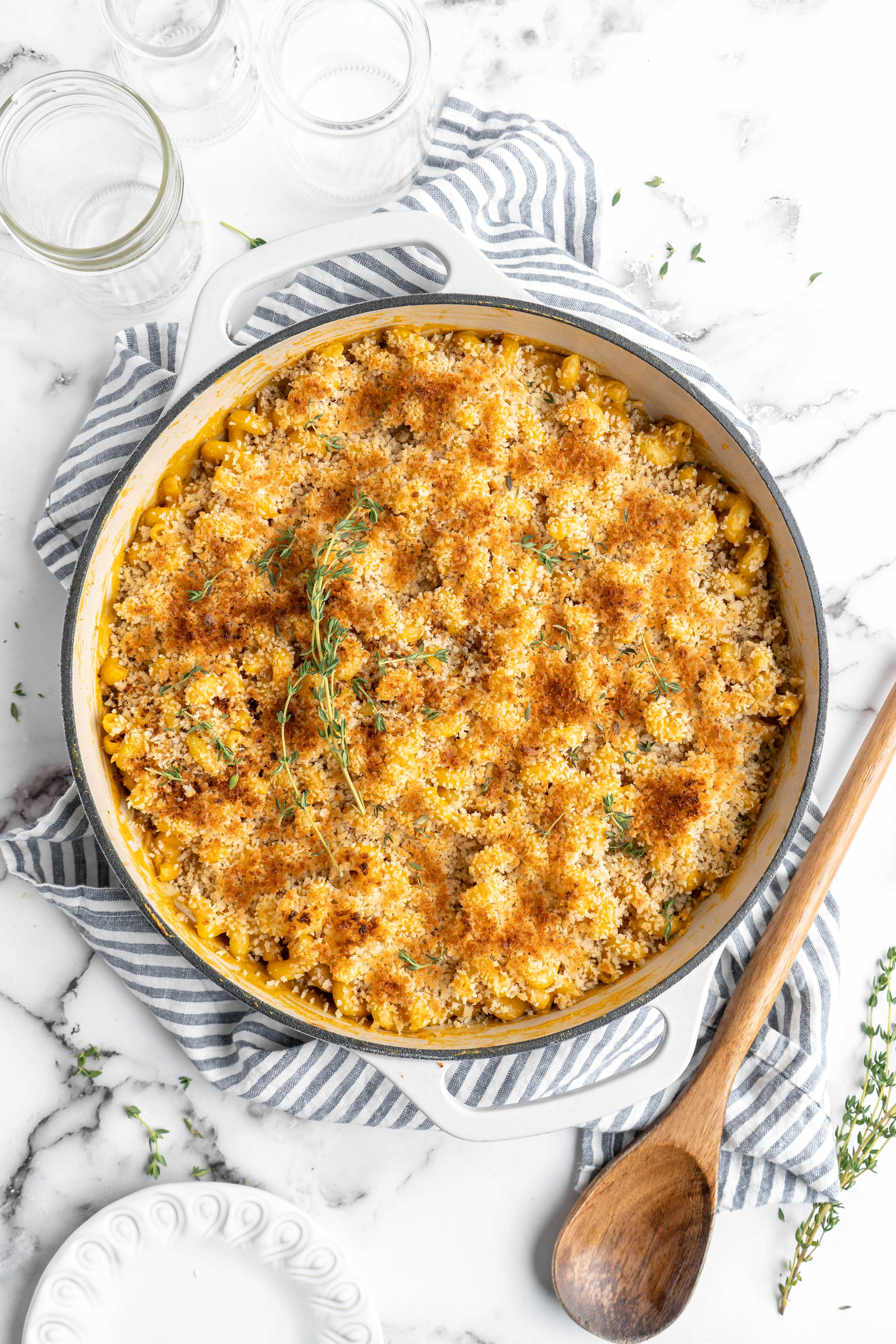 Vegan baked mac and cheese in pan, garnished with thyme sprigs