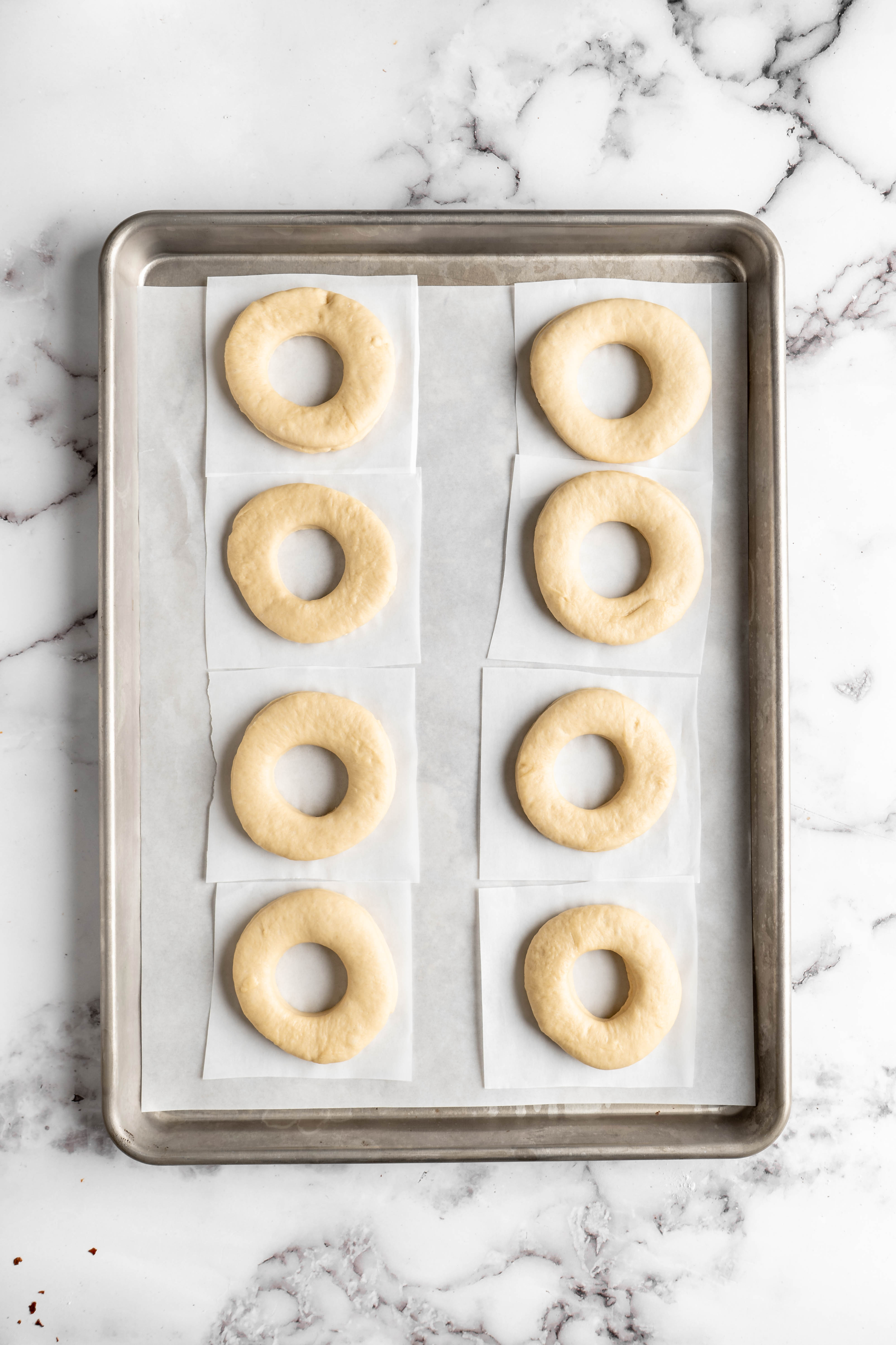 Uncooked donuts on parchment paper