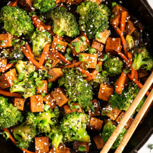 Veggie and tofu stir fry in cast iron skillet with chopsticks