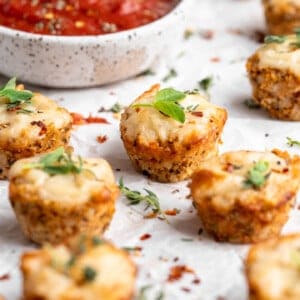 Cauliflower pizza bites with bowl of marinara in background