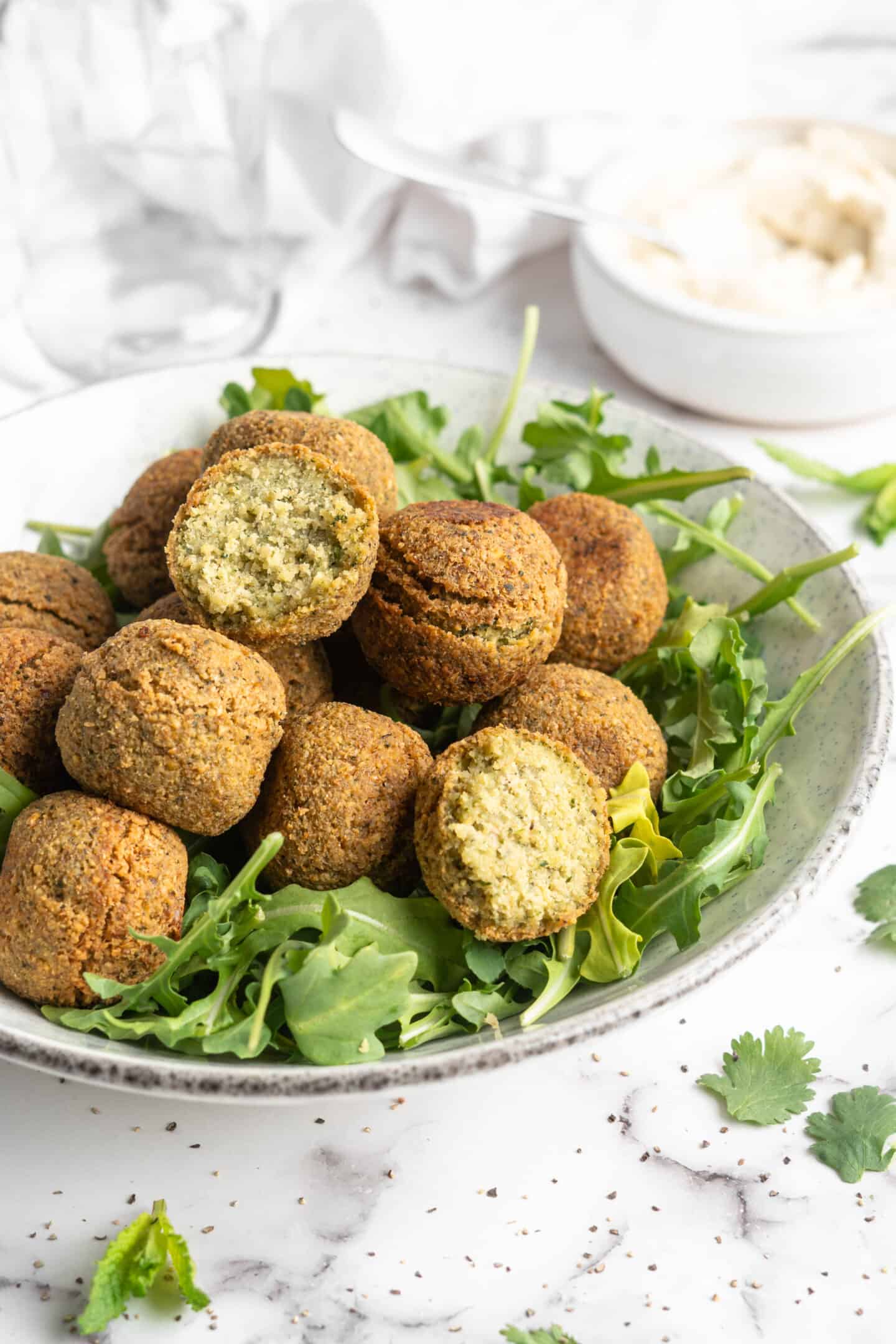 Falafel stacked in bowl of greens
