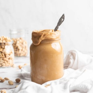 Jar of homemade peanut butter with spoon inside