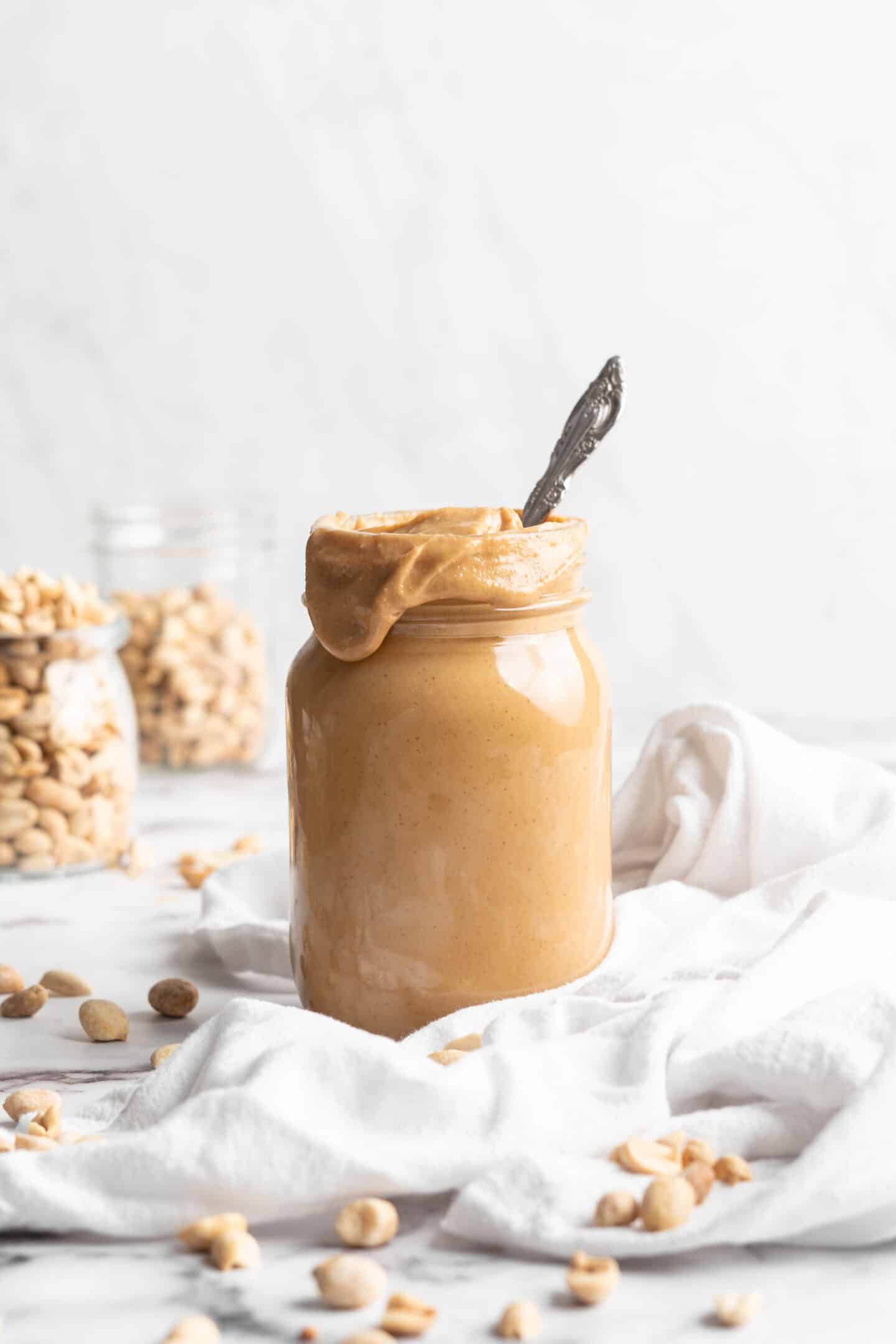 Jar of homemade peanut butter with spoon inside
