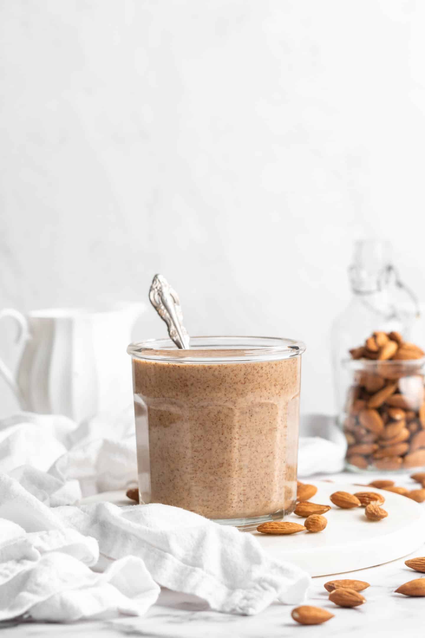 Jar of almond butter with spoon inside