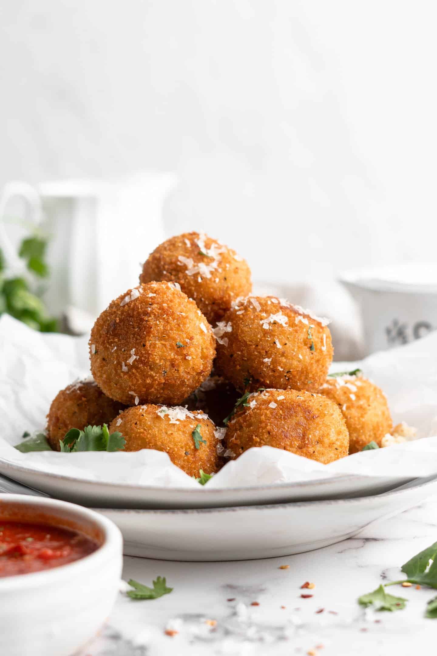 Pile of arancini on parchment-lined plate