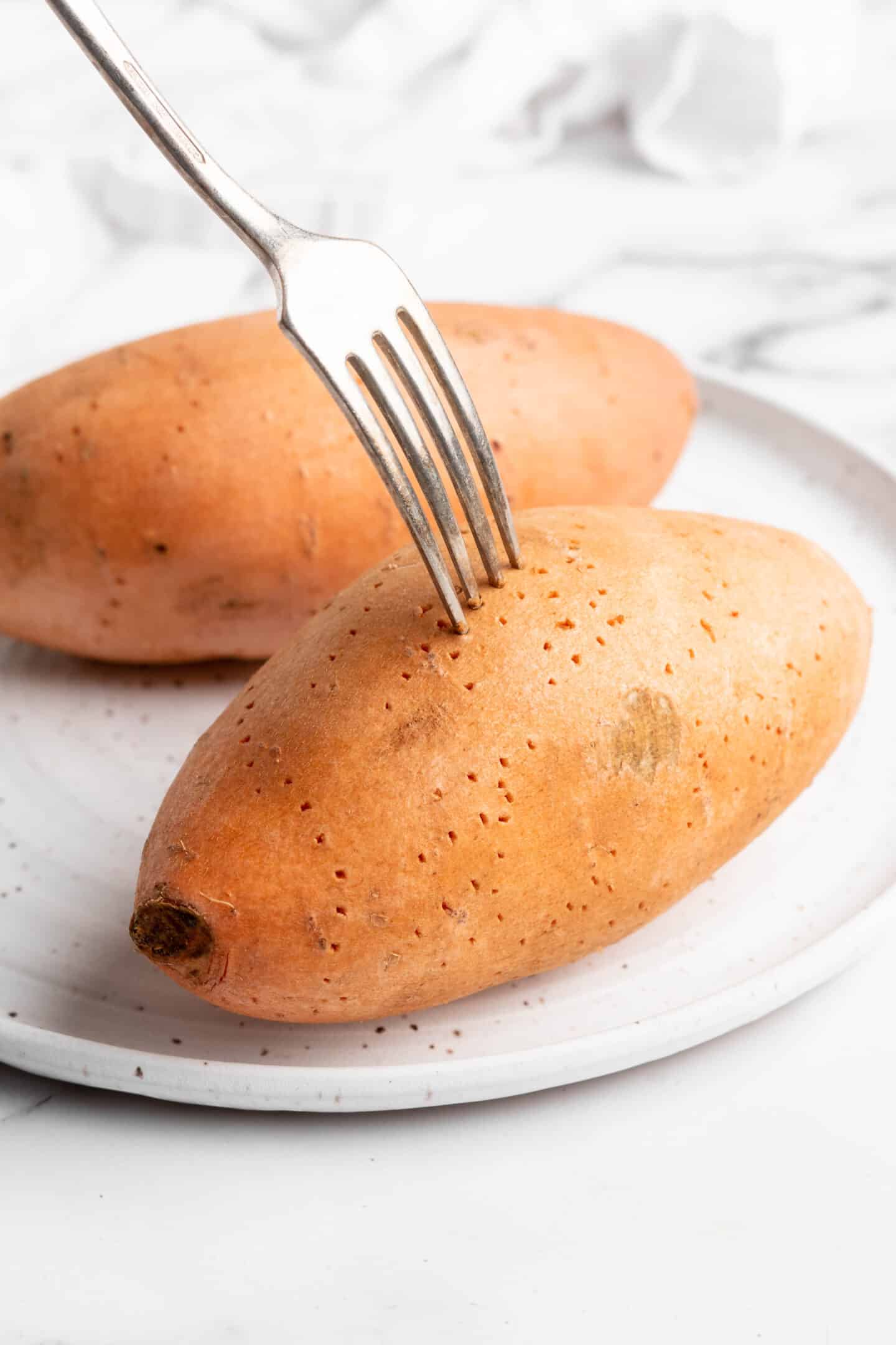 Poking sweet potato with fork