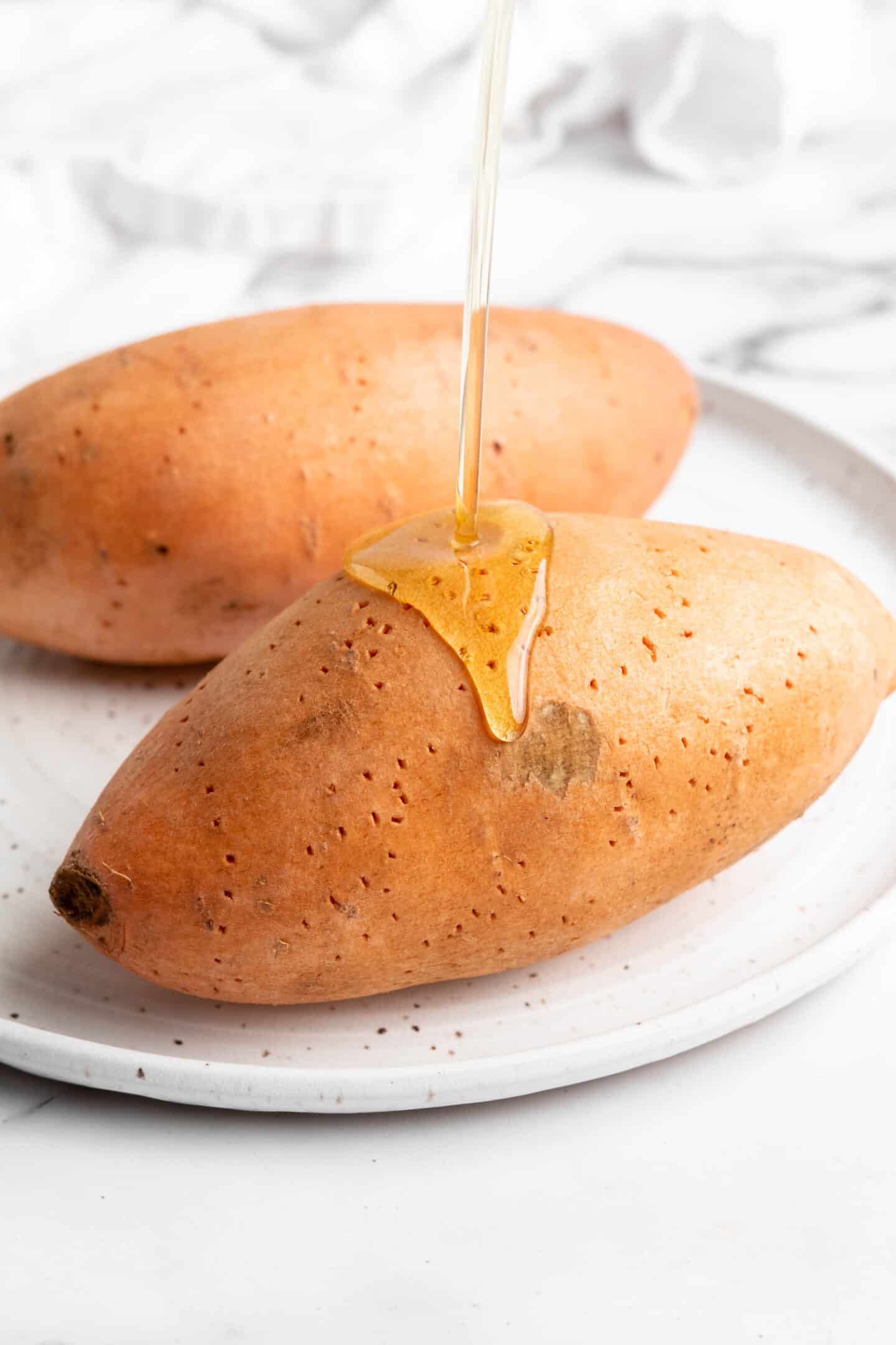 Pouring oil onto sweet potato