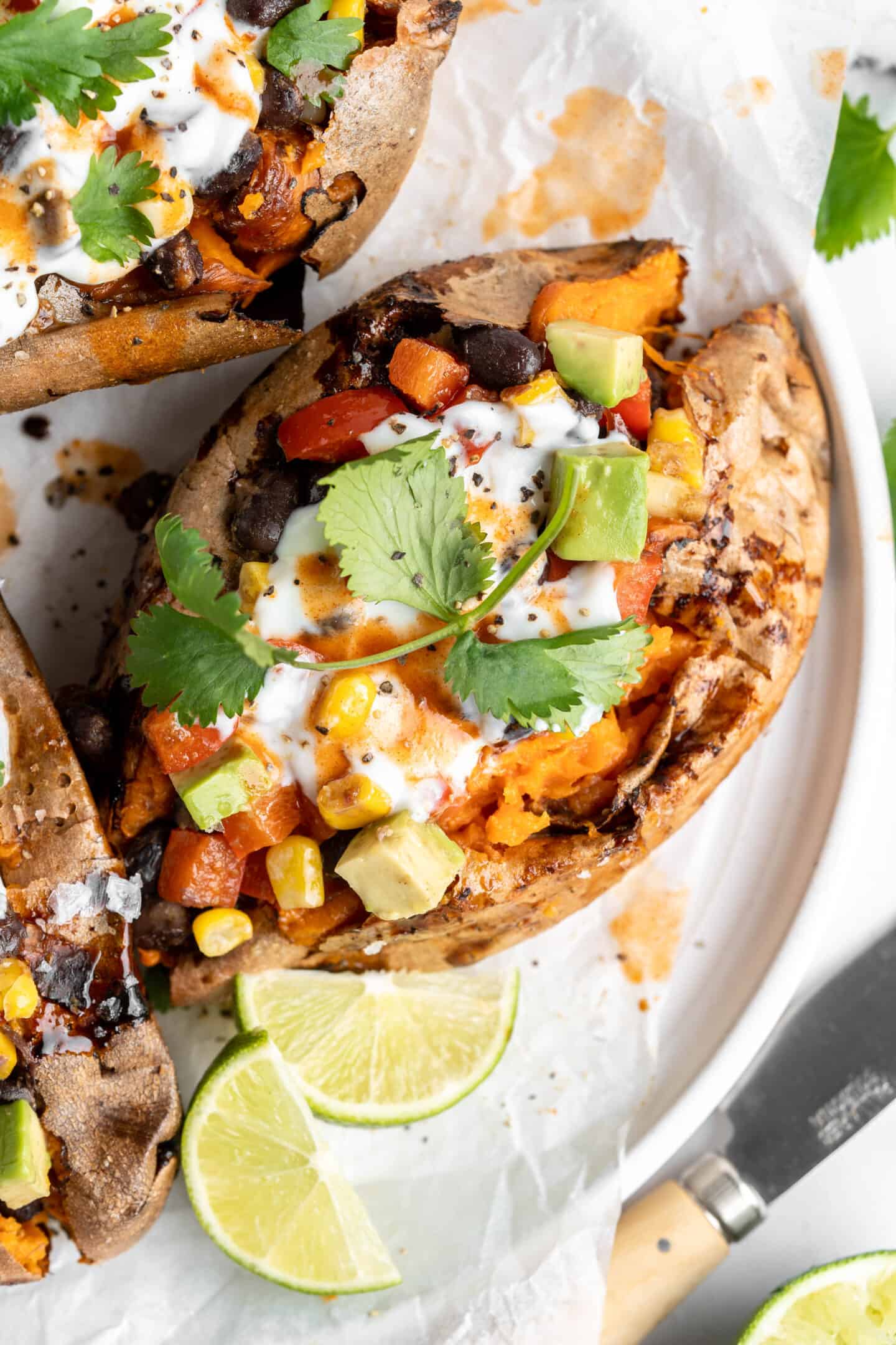Loaded air fryer sweet potatoes on plate with lime wedges