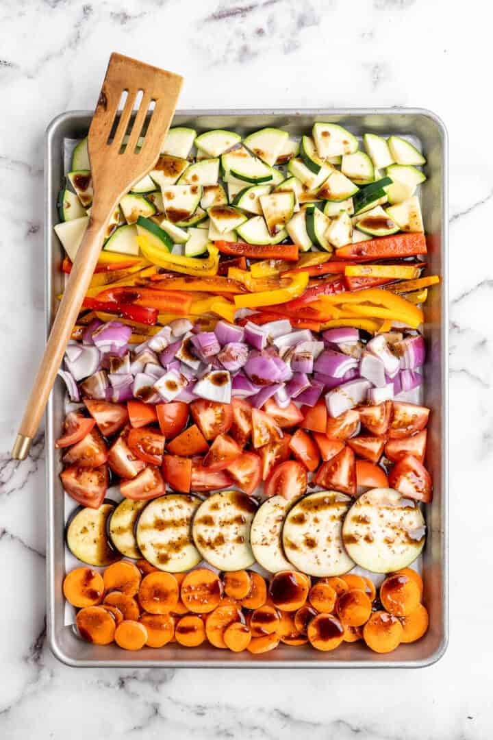 Rainbow of raw veggies on sheet pan, drizzled with balsamic sauce