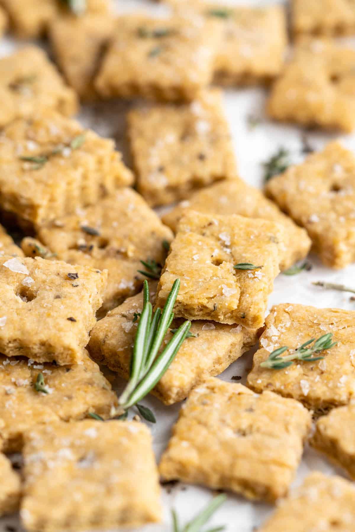 Vegan cheez-its on parchment paper with rosemary