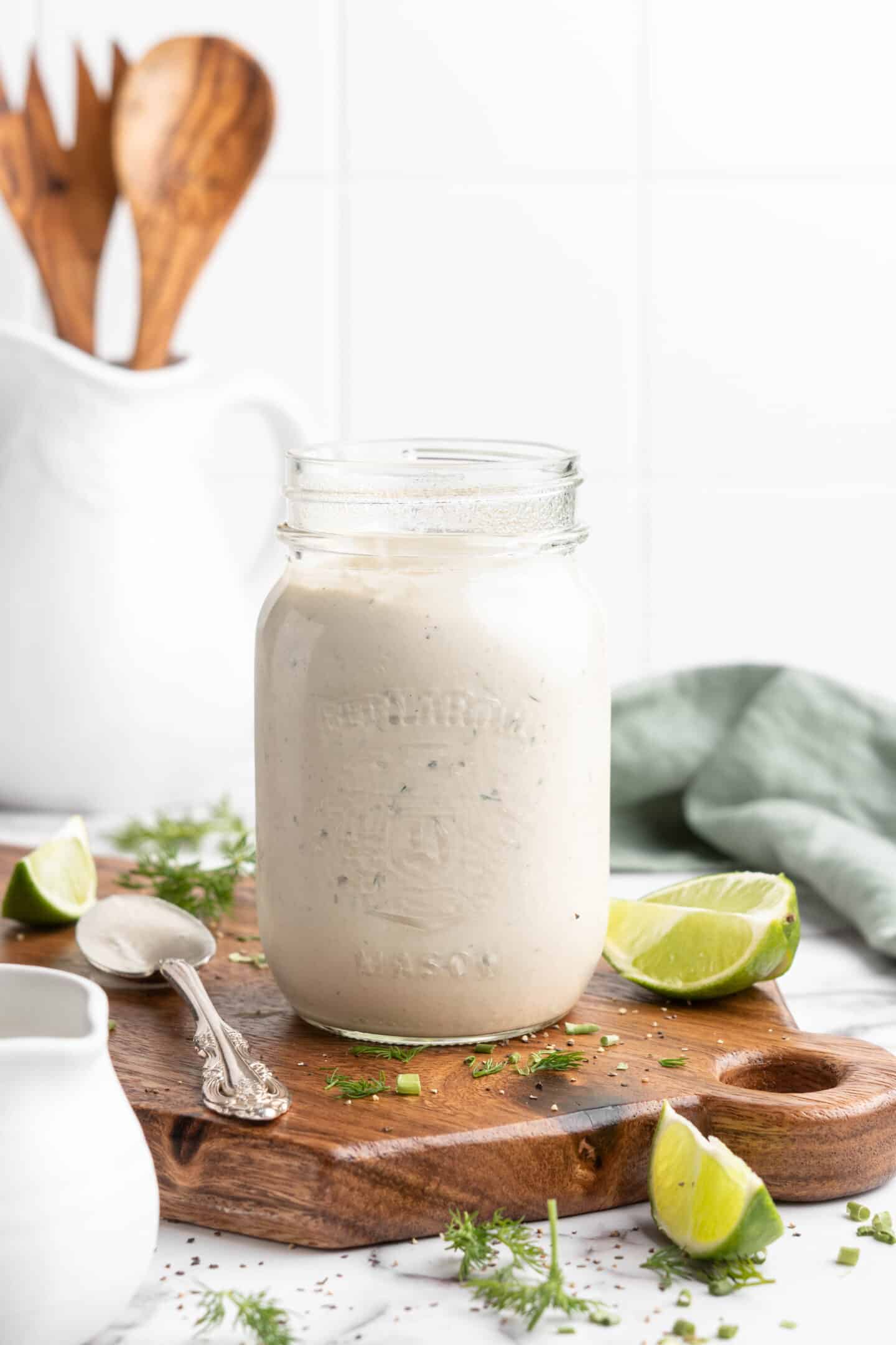 Jar of vegan ranch dressing on wood cutting board