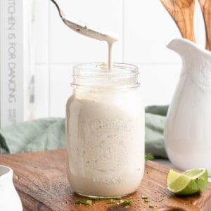 Spoon drizzling vegan ranch dressing into jar