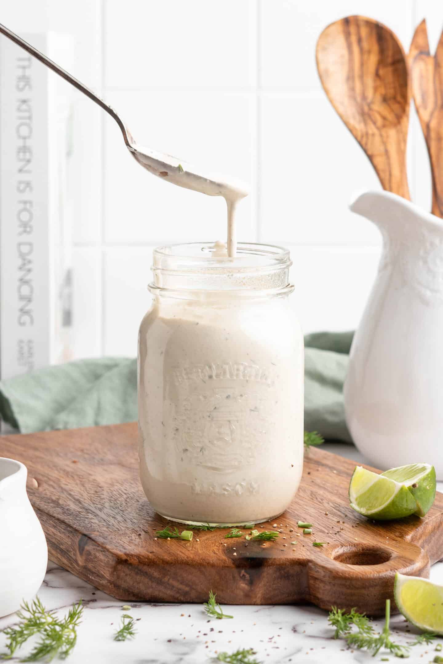 Spoon drizzling vegan ranch dressing into jar