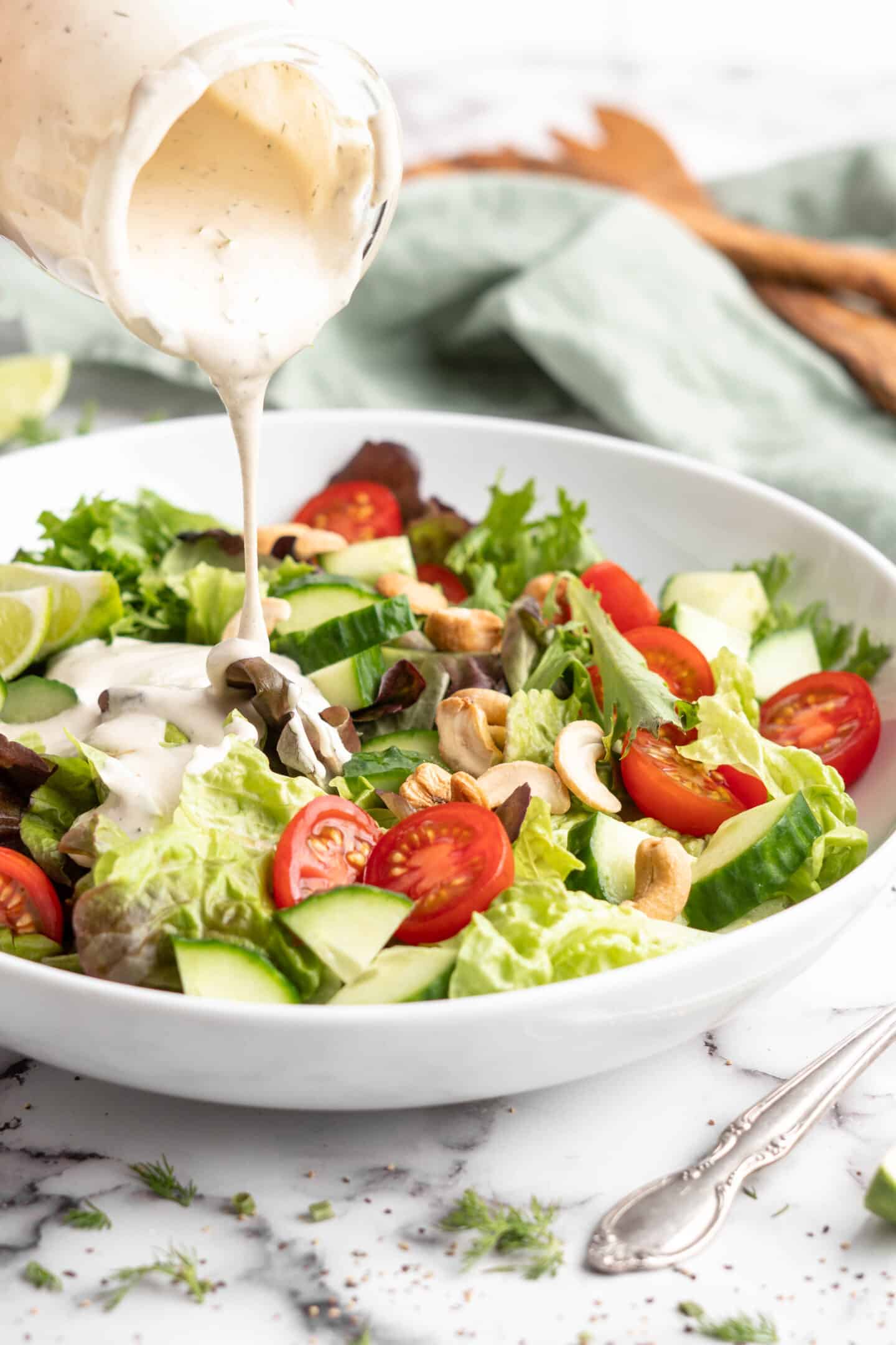 Pouring vegan ranch dressing onto salad