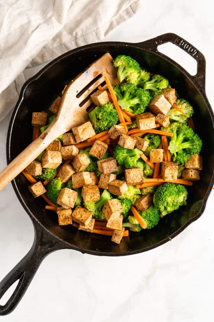 Overhead view of tofu and veggies in cast iron skillet