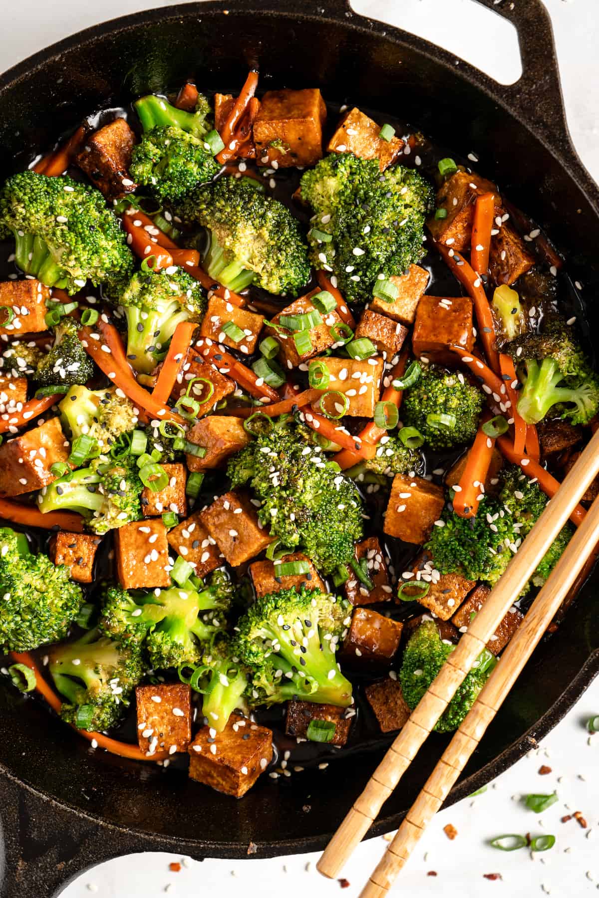 Veggie and tofu stir fry in cast iron skillet with chopsticks