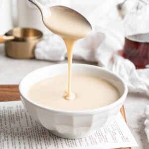 Spoon drizzling vegan condensed milk into bowl