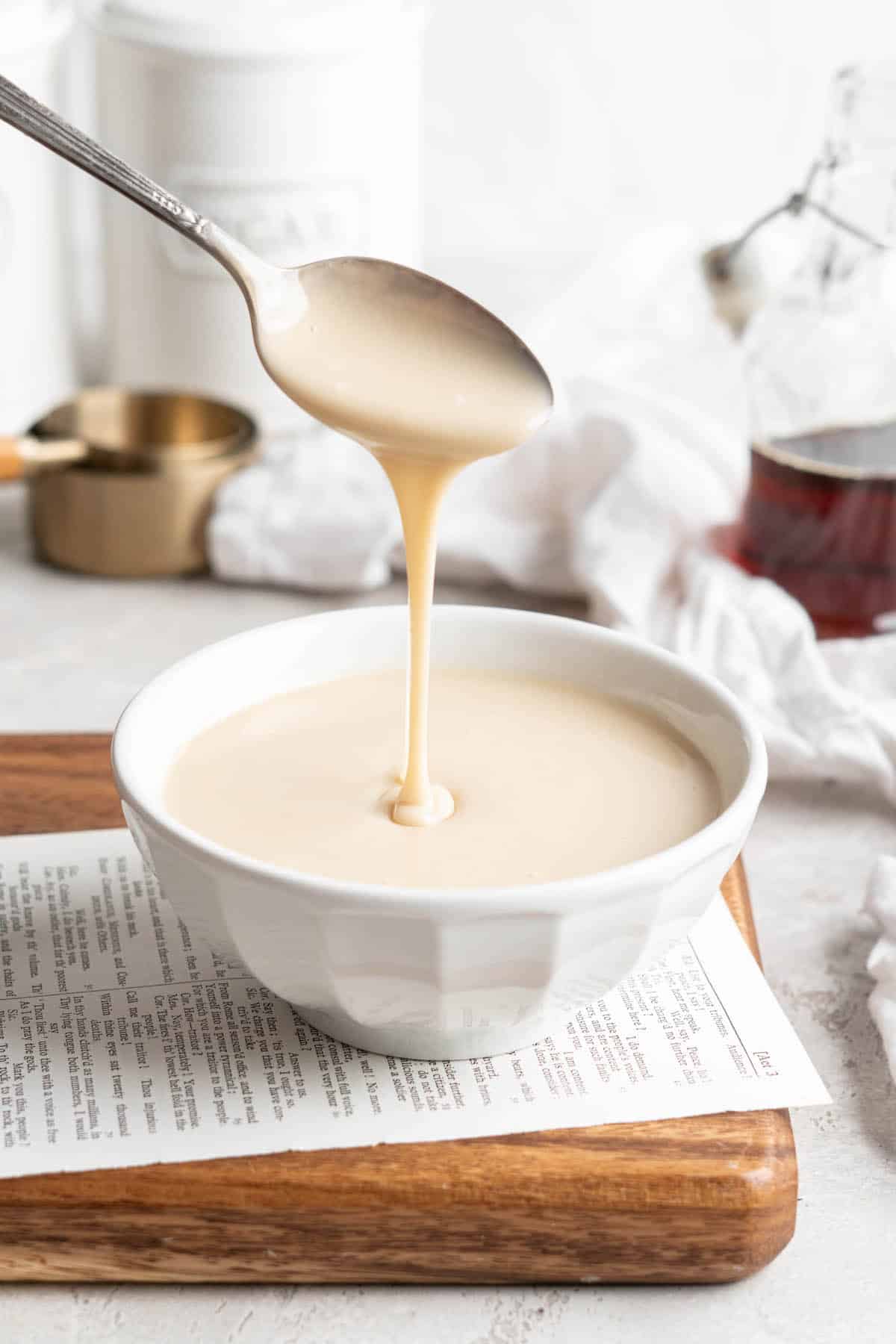 Spoon drizzling vegan condensed milk into bowl
