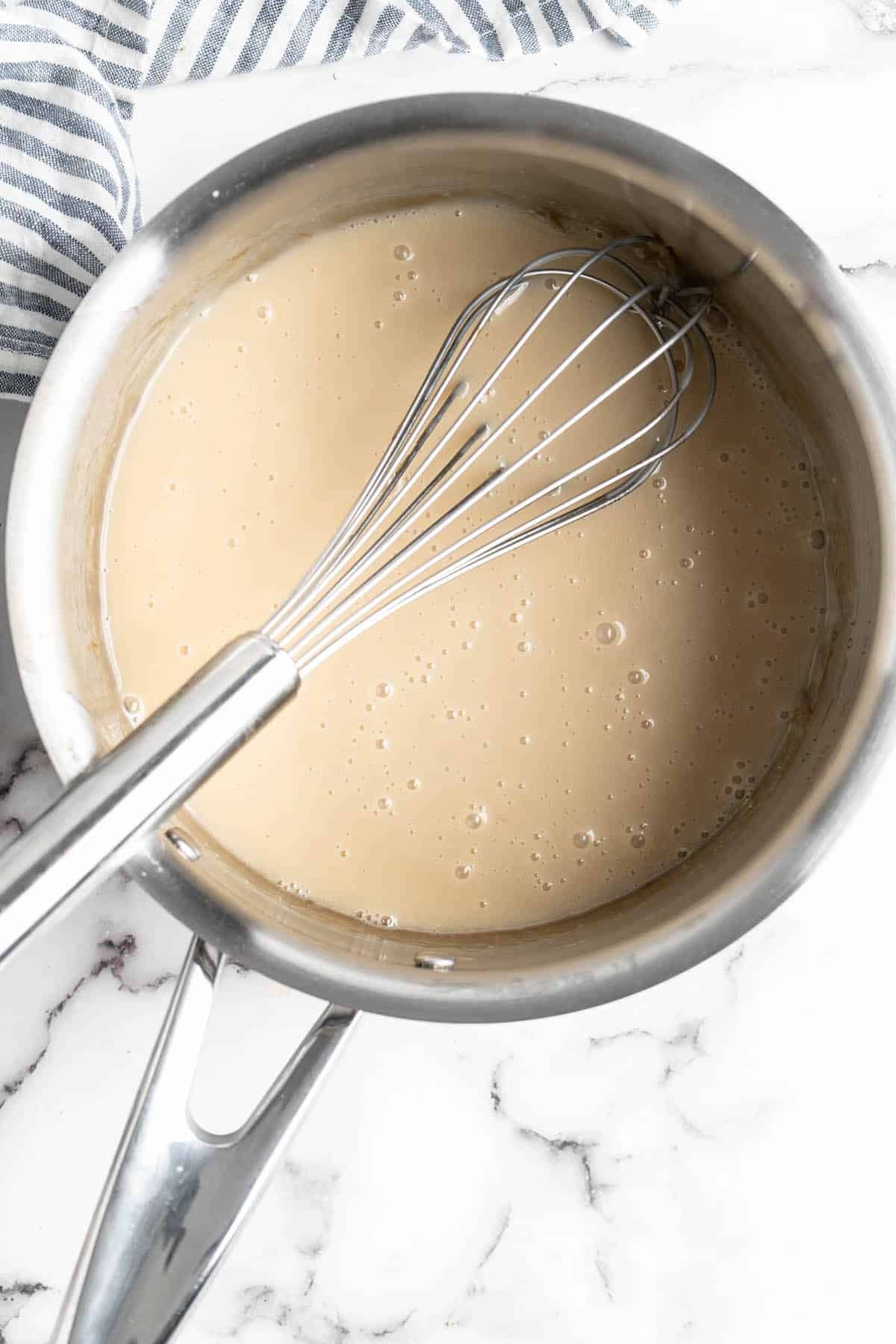 Vegan condensed milk in pan with whisk