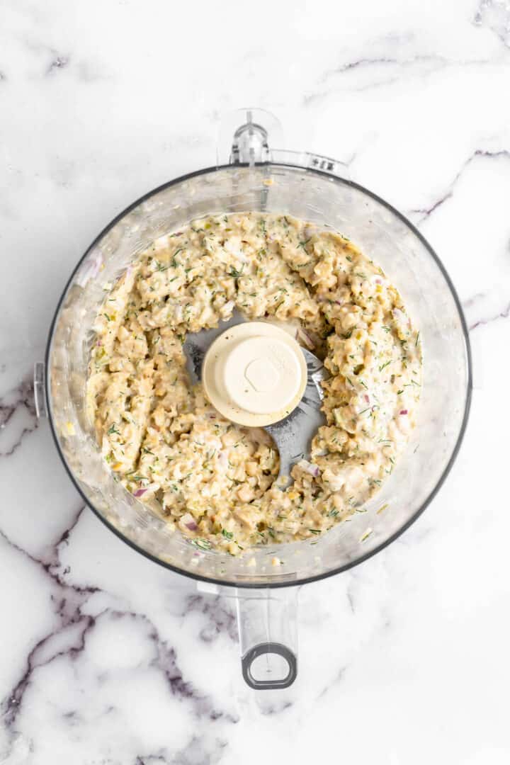 In just 15 minutes, you can make a creamy, flavourful chickpea tuna salad to layer onto sandwiches or include in your meal prep lunches! Overhead view of vegan chickpea tuna salad in food processor bowl