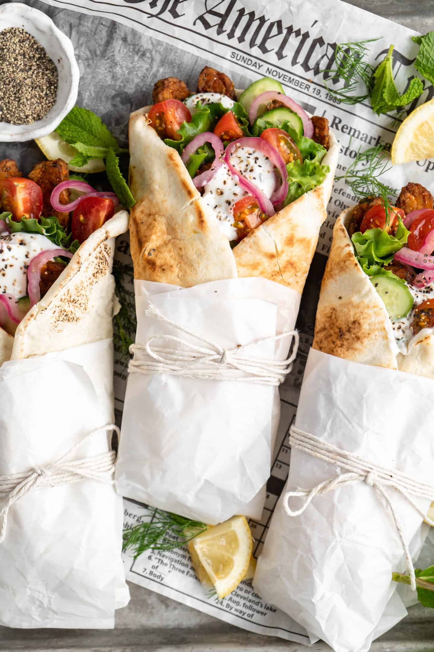 3 vegan gyros wraps wrapped in parchment and string