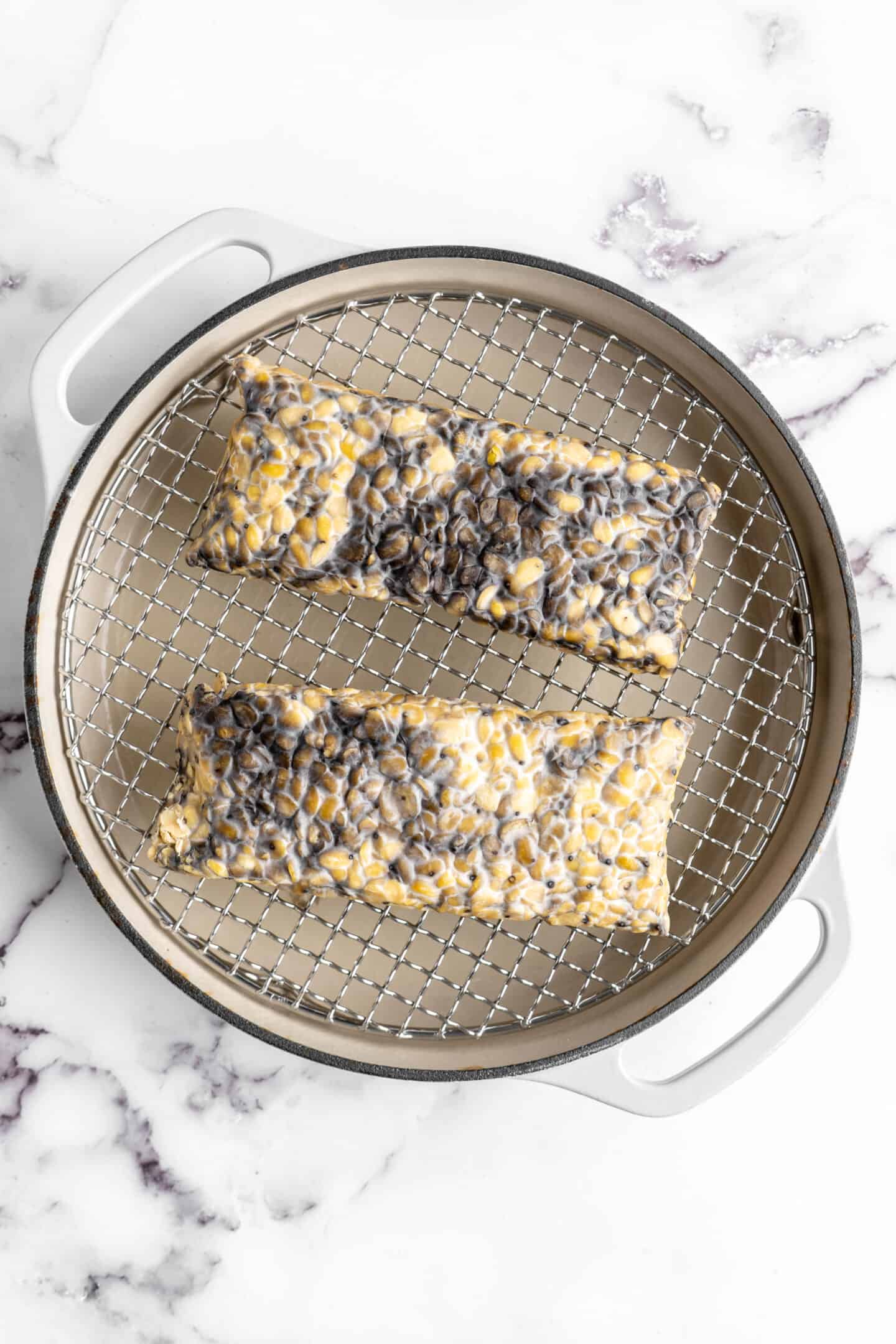 Two slabs of tempeh set over steamer