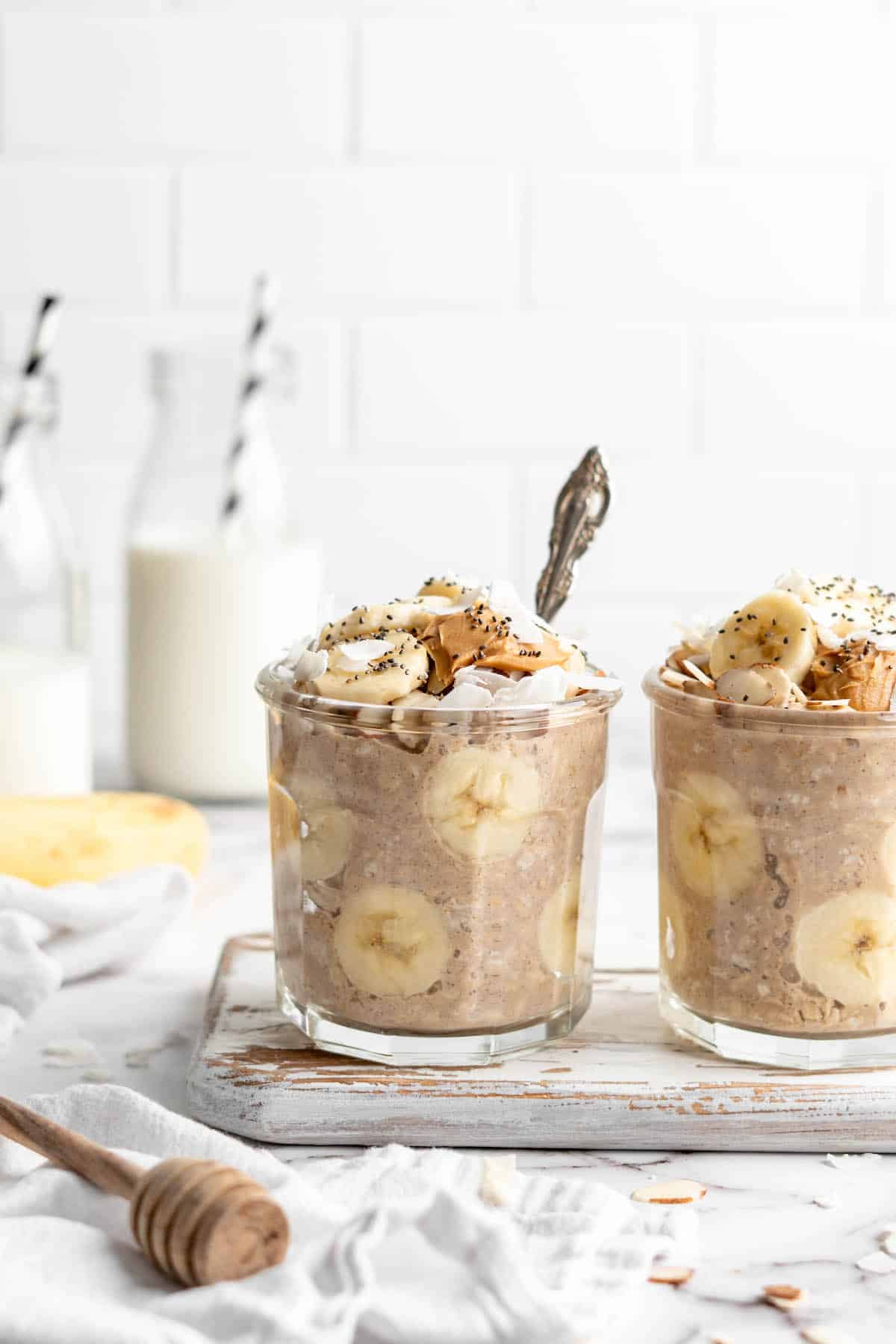 Two jars of overnight oats with bananas and peanut butter