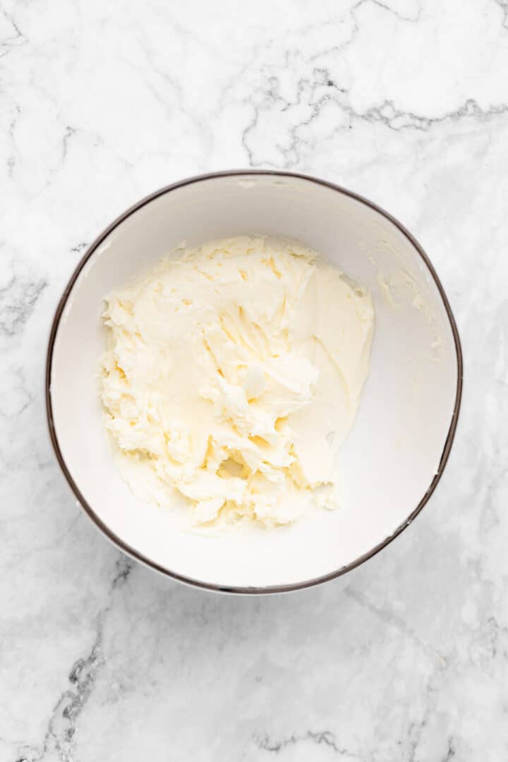Overhead view of creamed butter and cream cheese in mixing bowl