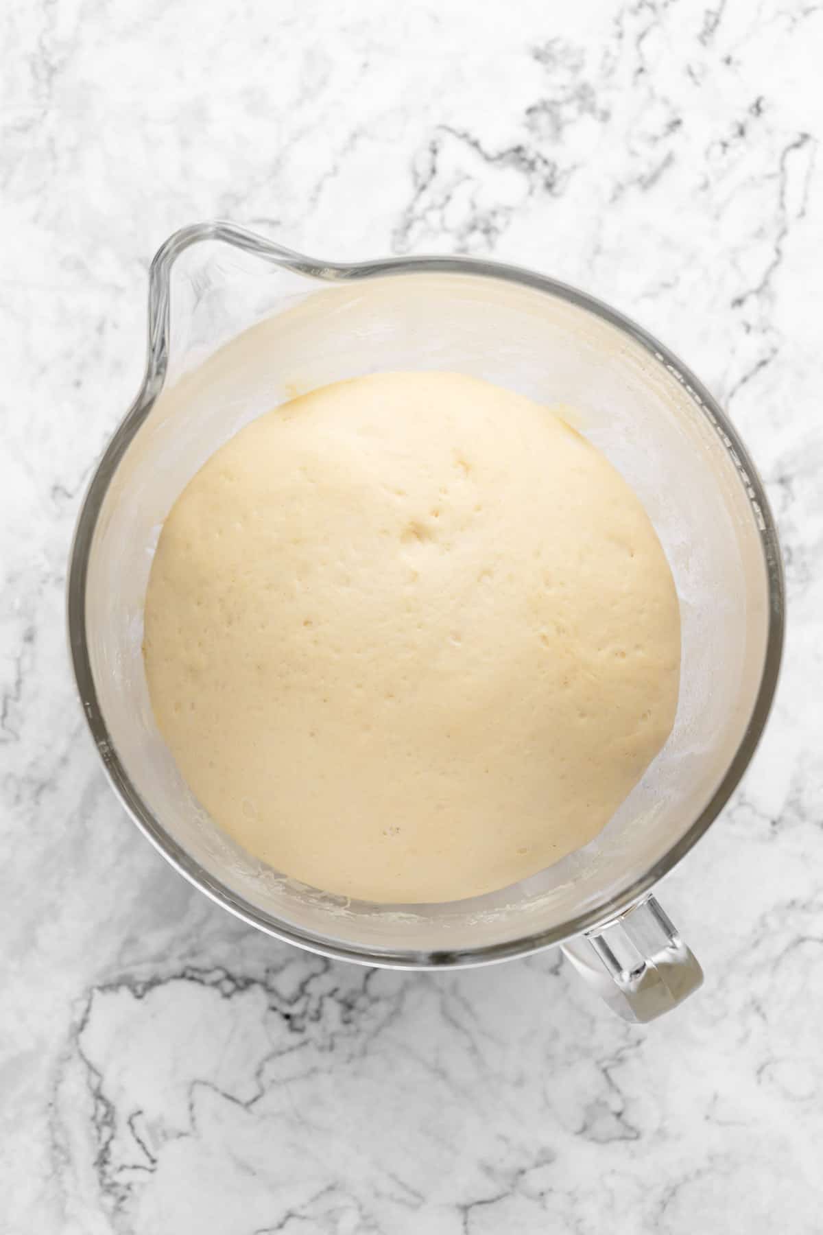 Overhead view of dough in glass mixing bowl