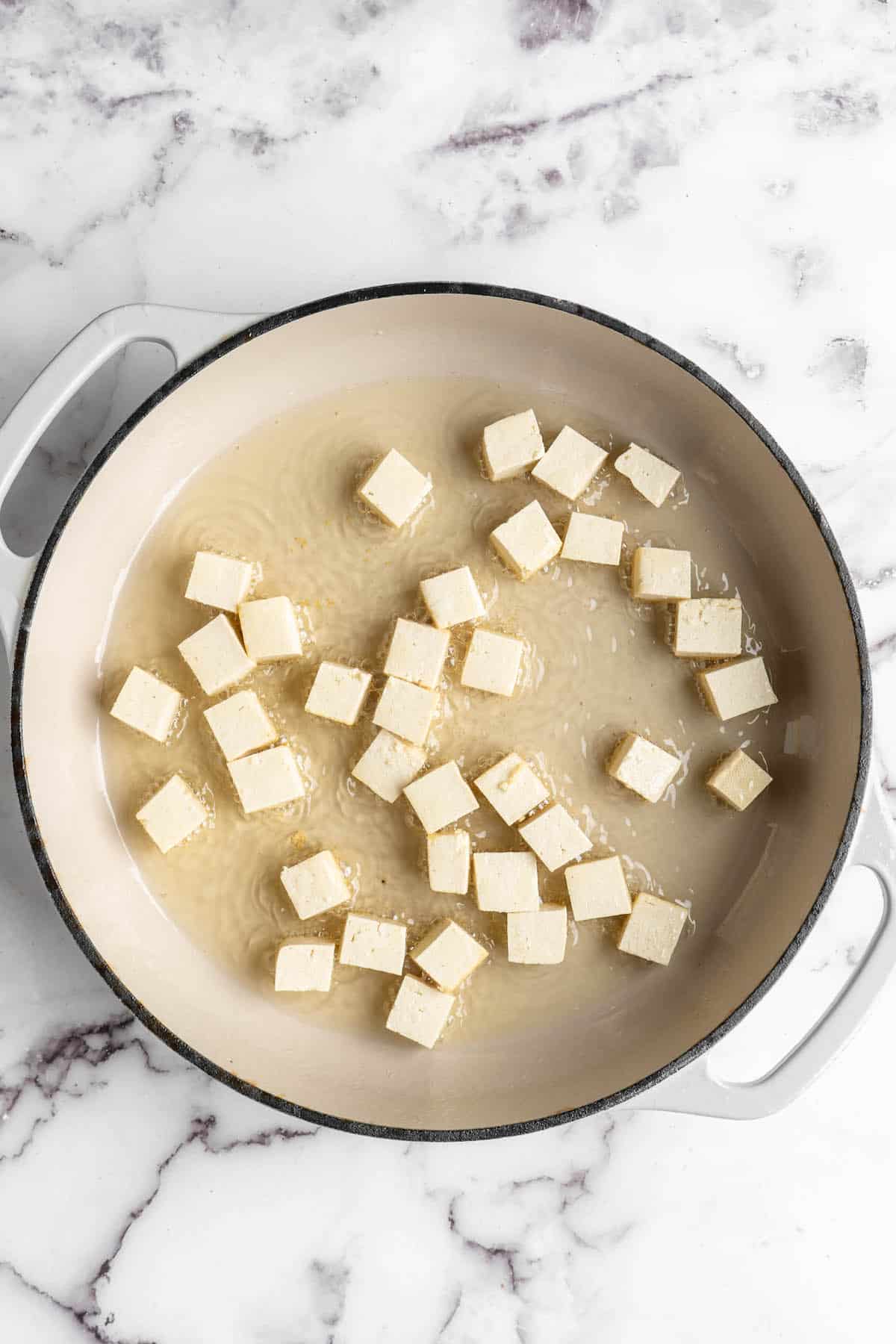 Overhead view of tofu cubes after adding to skillet