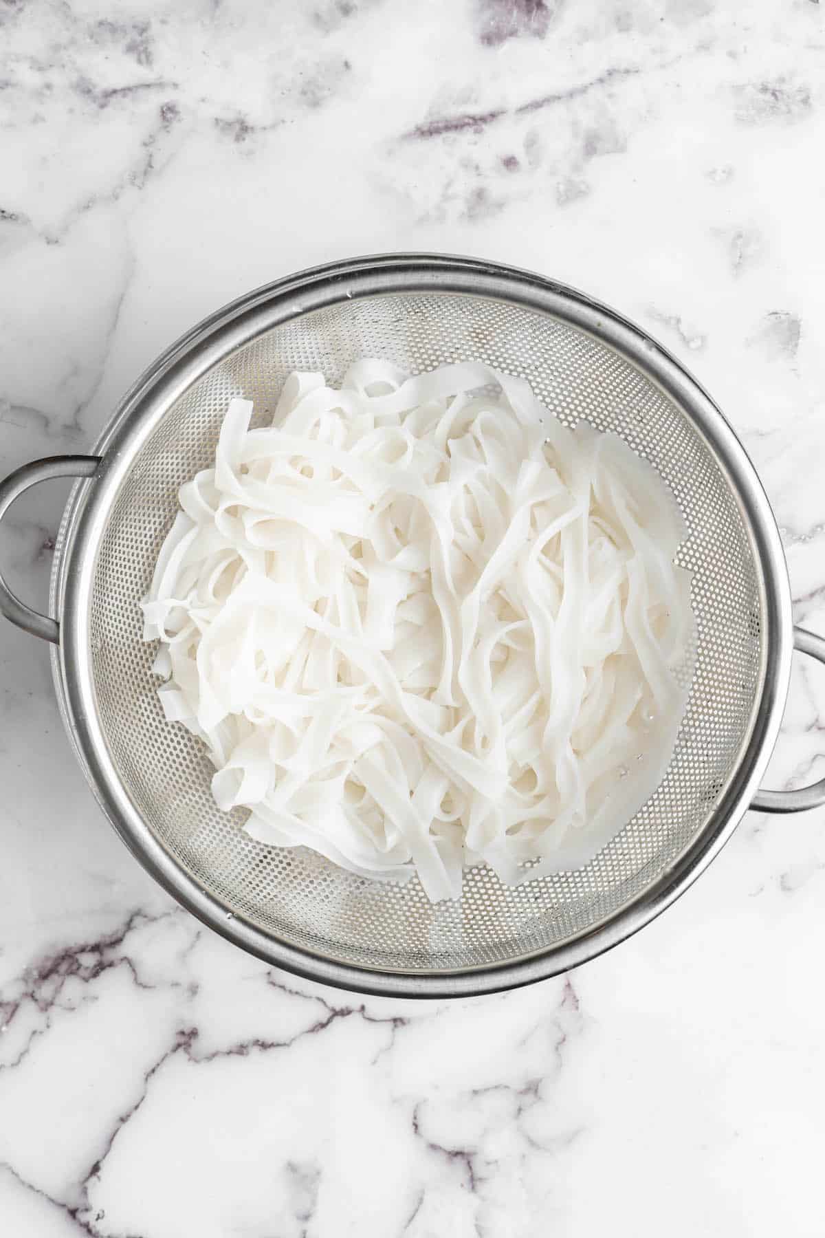 Overhead view of rice noodles in colander