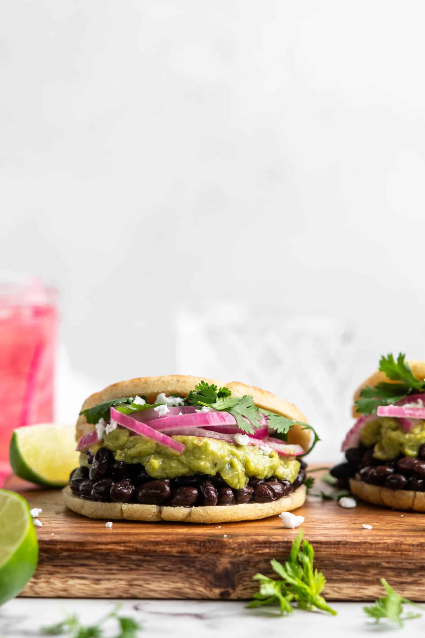 Two vegan arepas with toppings on cutting board