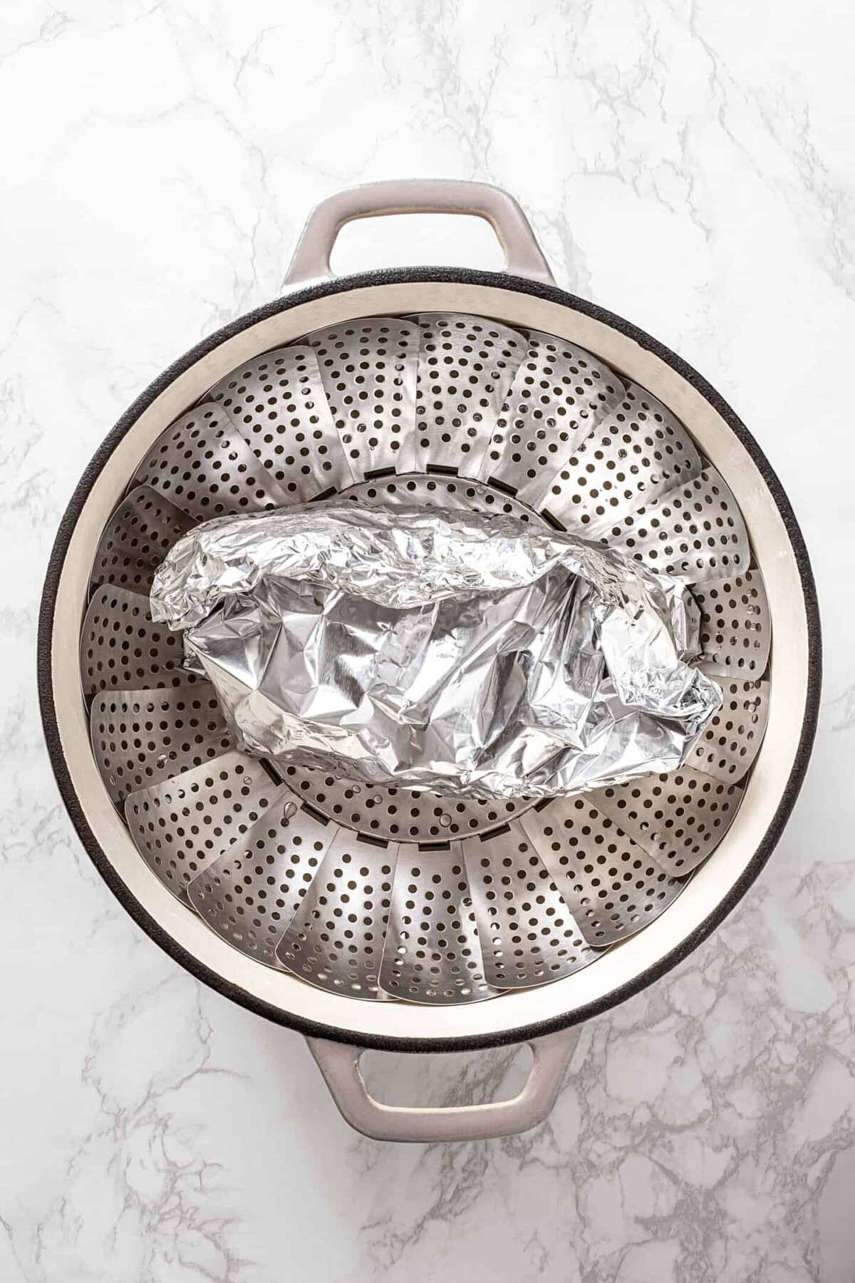 Tin foil-wrapped vegan turkey roast in a steamer