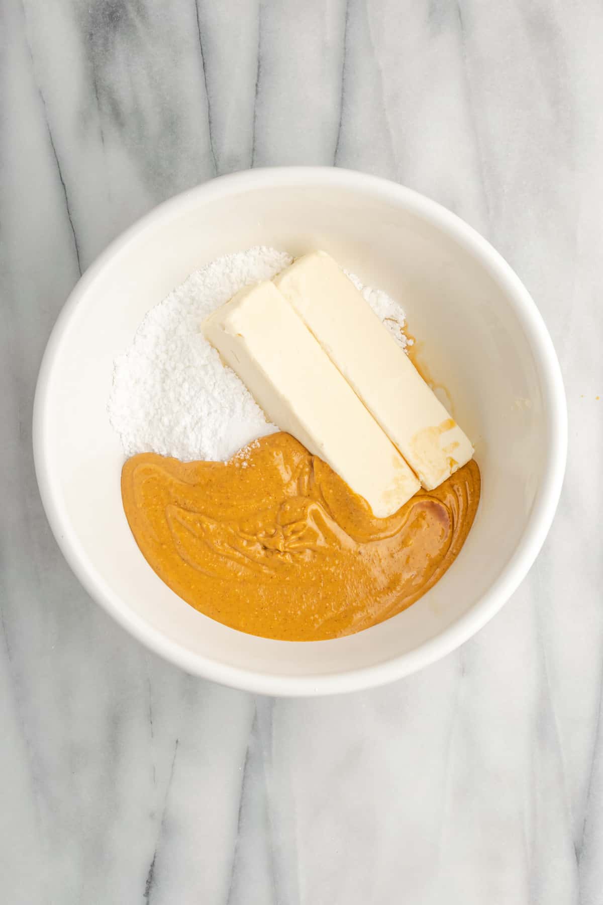 A bowl of peanut butter, butter, and sugar