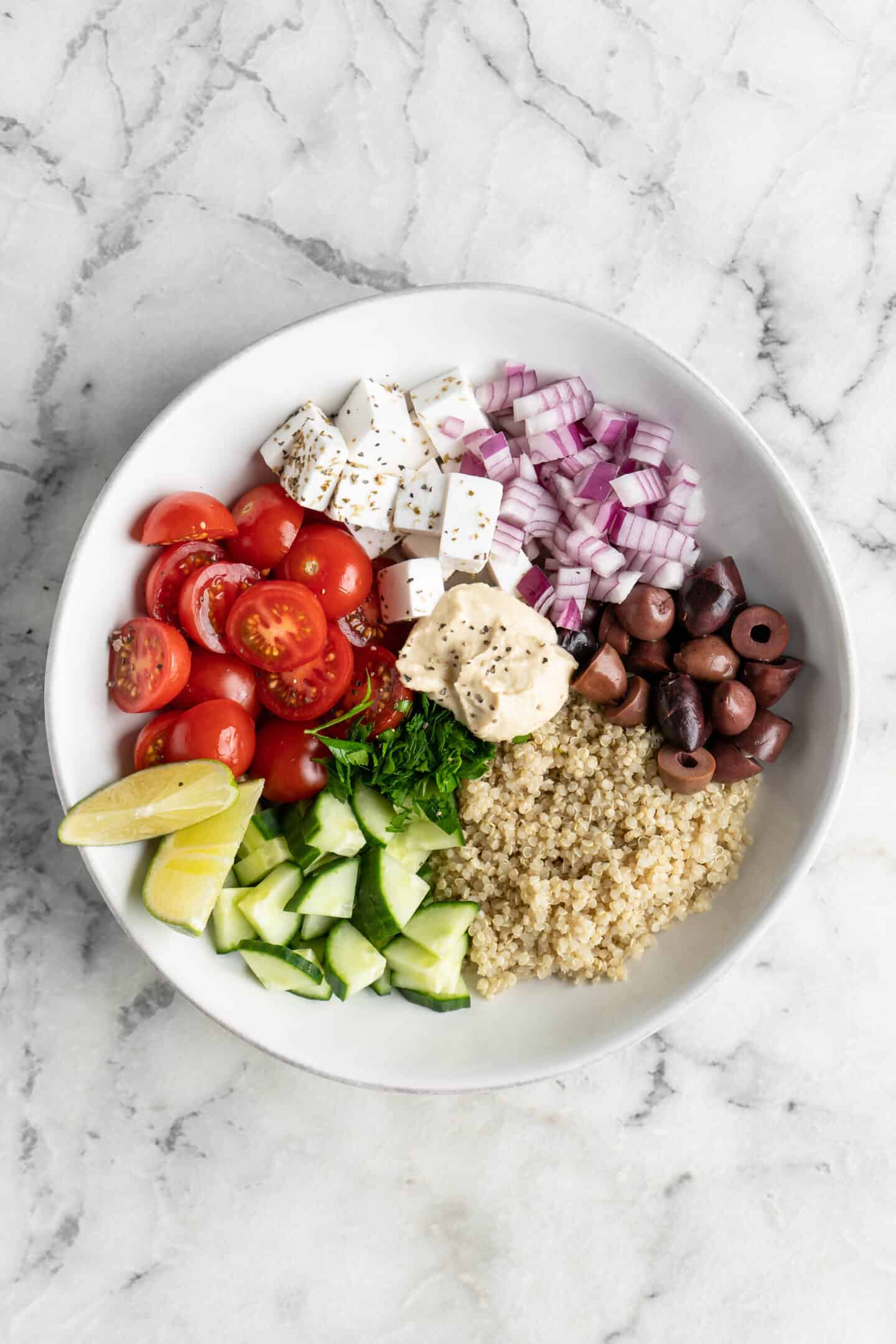 A white bowl with cucumber quinoa salad