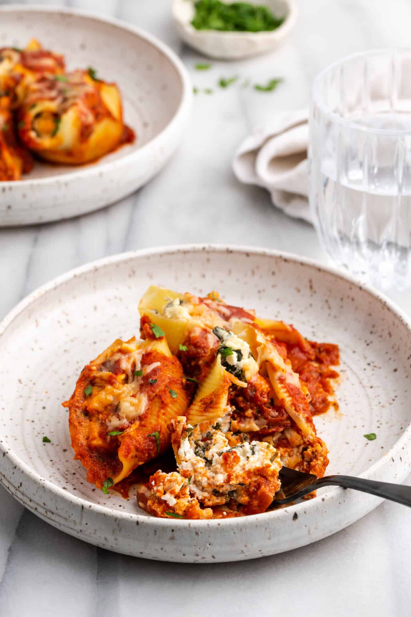 Single serving of vegan stuffed shells with a fork in it