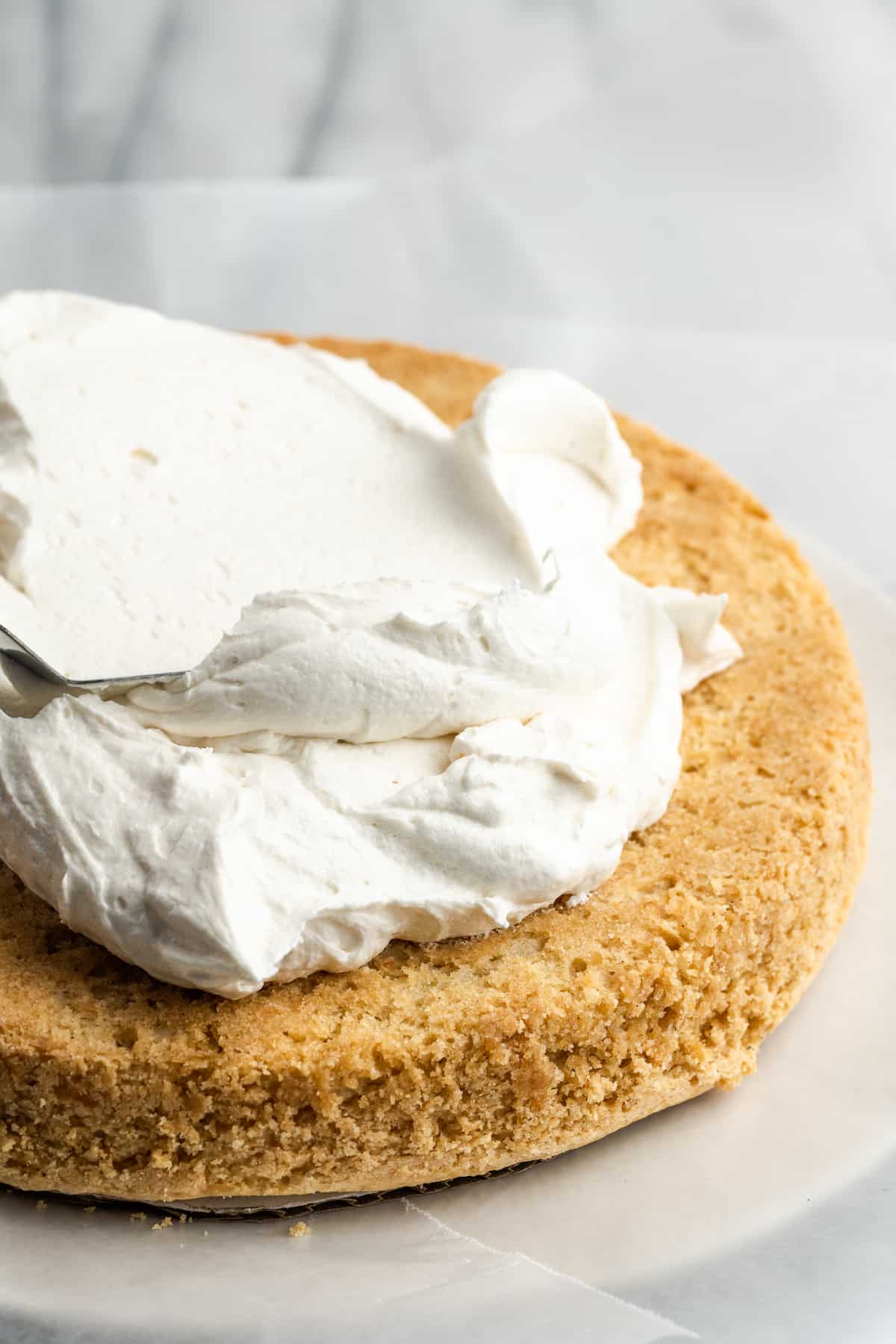 applying frosting to vegan coconut cake