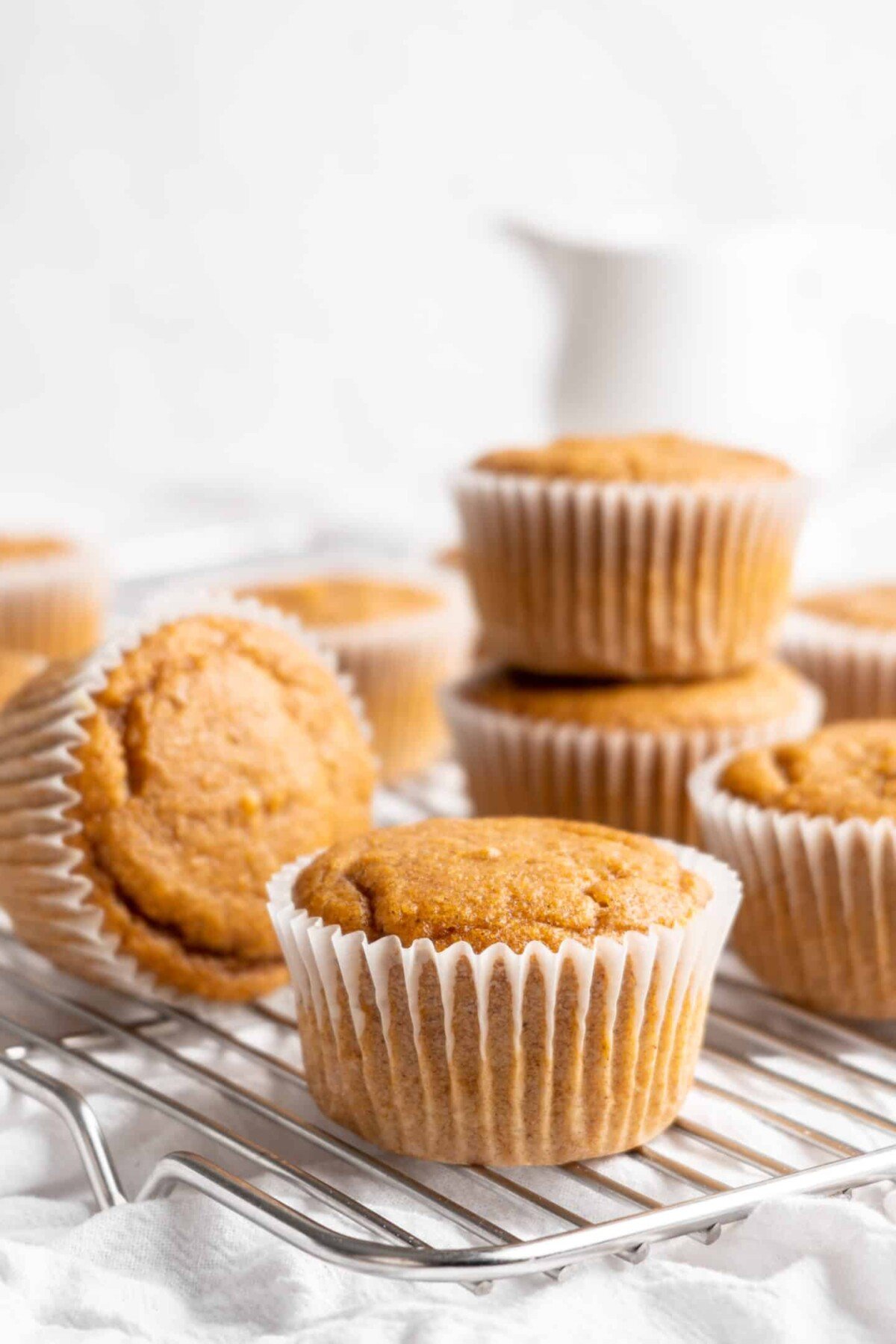 A scattered pile of pumpkin cupcakes that haven't been frosted.