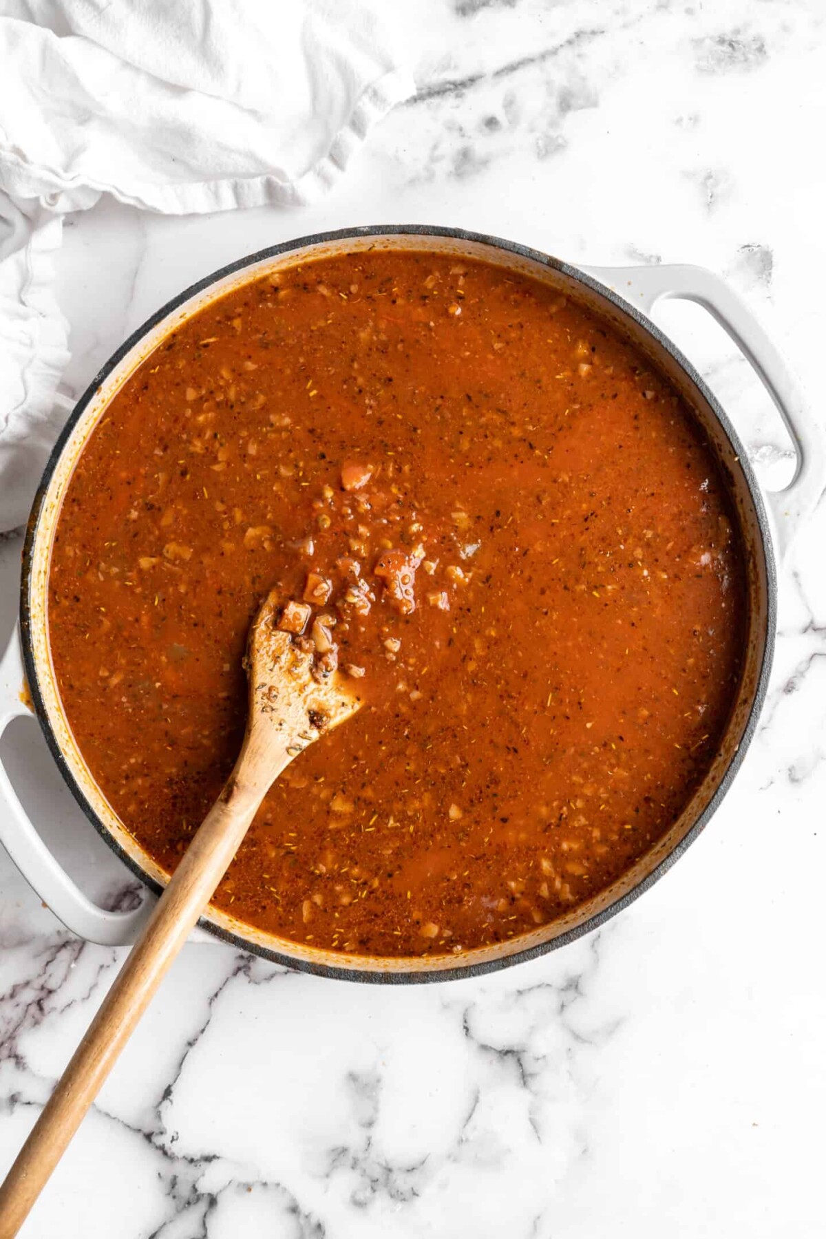 A pot with walnut lentil bolognese cooking in it, with lots of broth